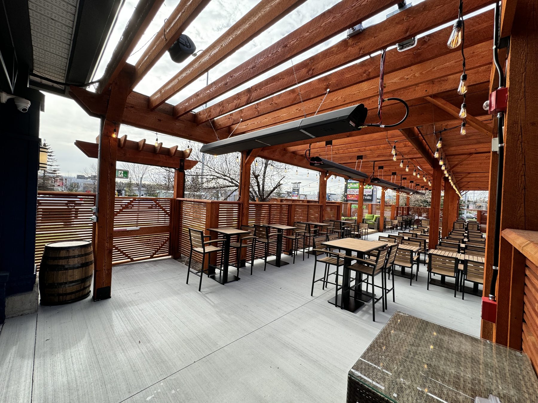 Outdoor patio construction with wood beams, tables, chairs, and heaters — Blowers and Grafton (Medicine Hat)