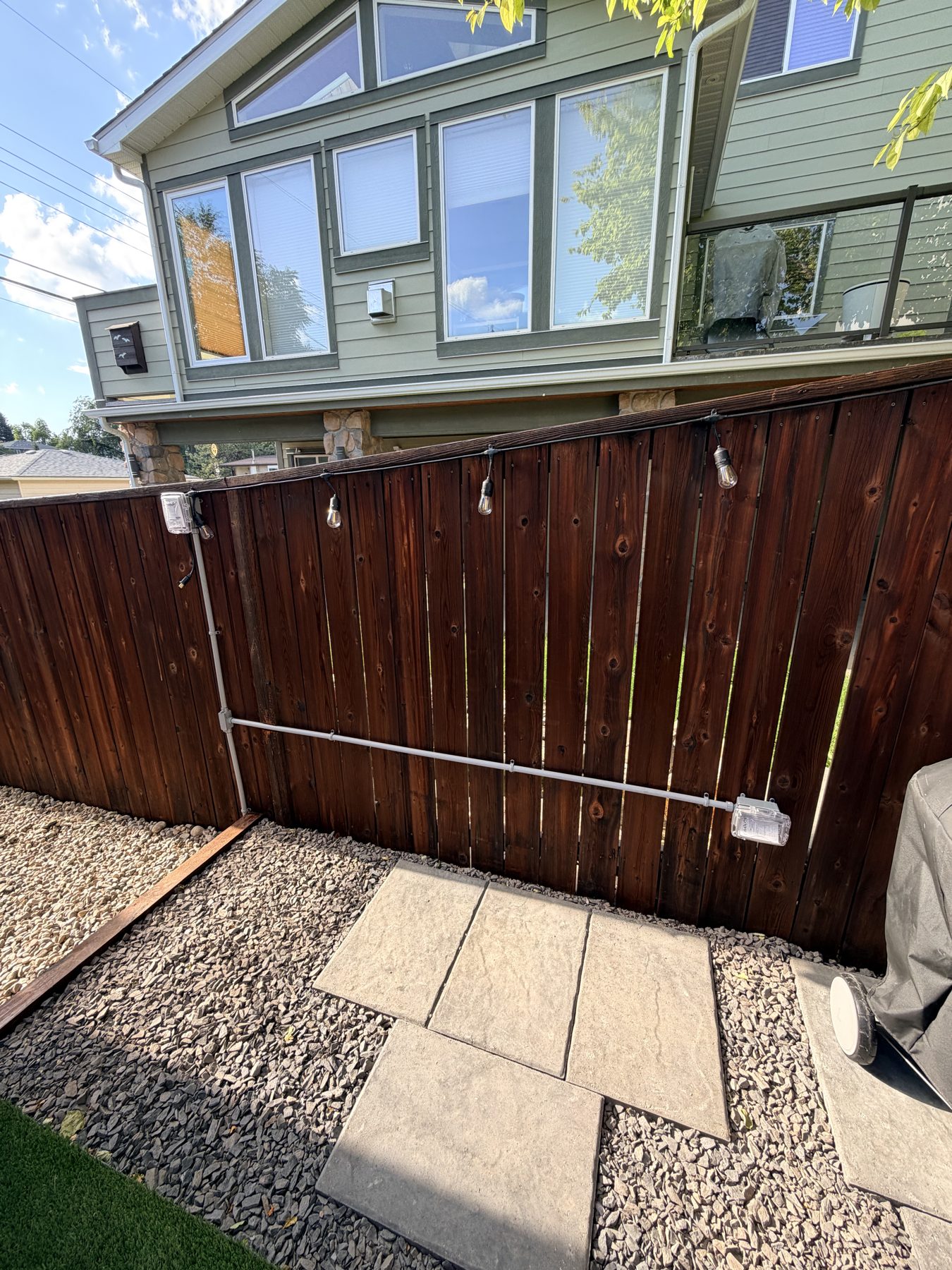 Wooden fence with outdoor lighting, gravel patio, and new pavers — 3505 41 Street SW, Calgary