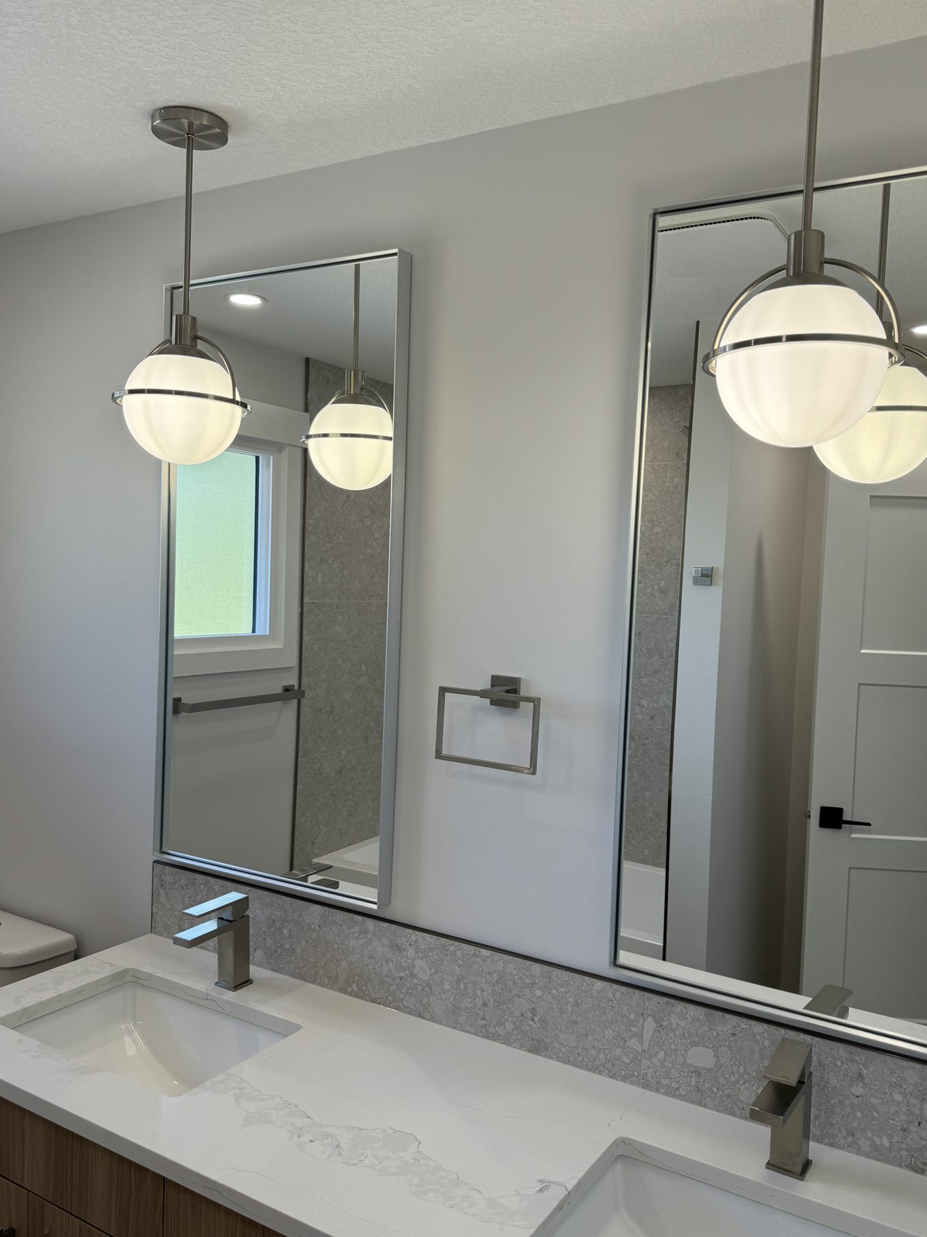Modern bathroom renovation with dual sinks and pendant lights — Lake Bonavista