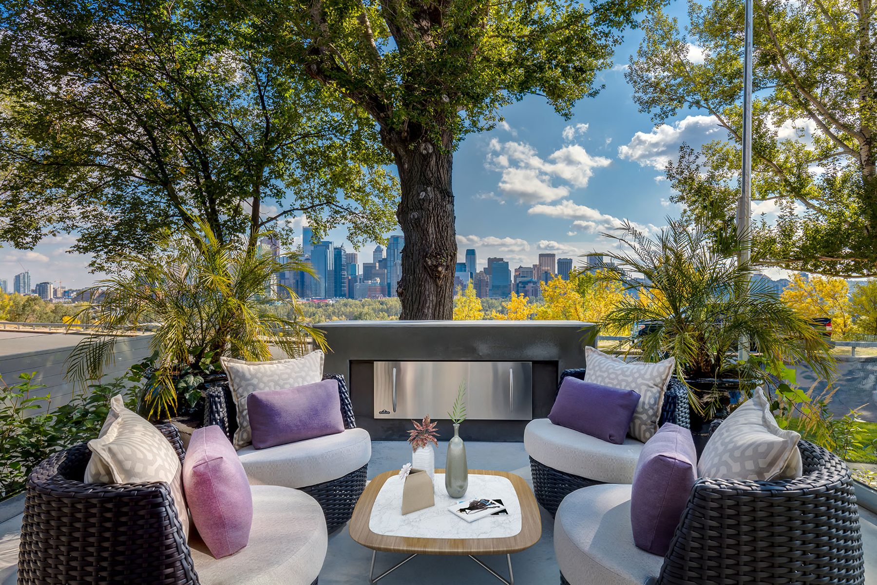 Outdoor living space with fireplace, seating, and city skyline view — Skyline
