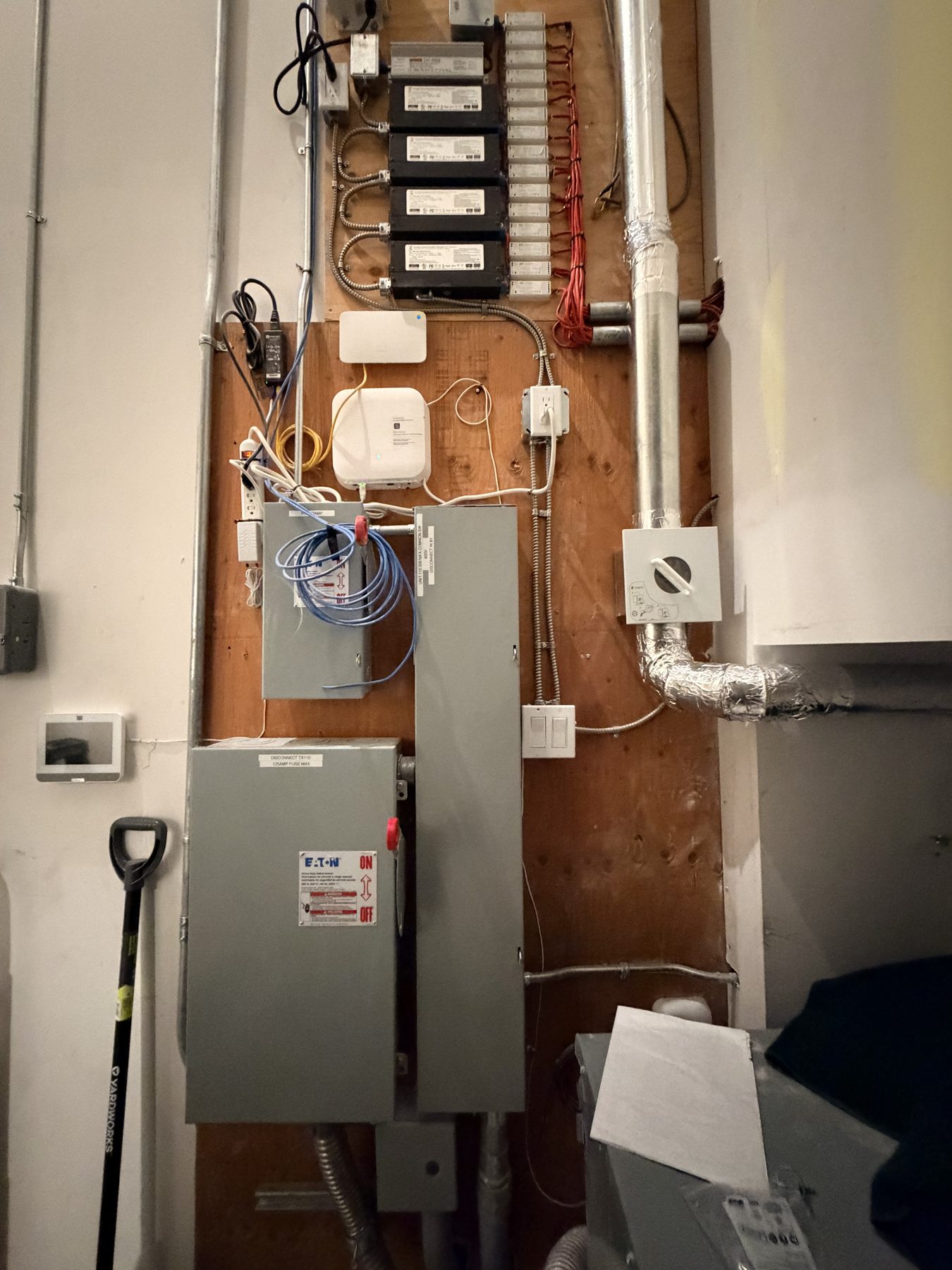 Electrical panel, conduit, wires, and ductwork on plywood wall — Cedar Steam and Spa (Trinity Hills)