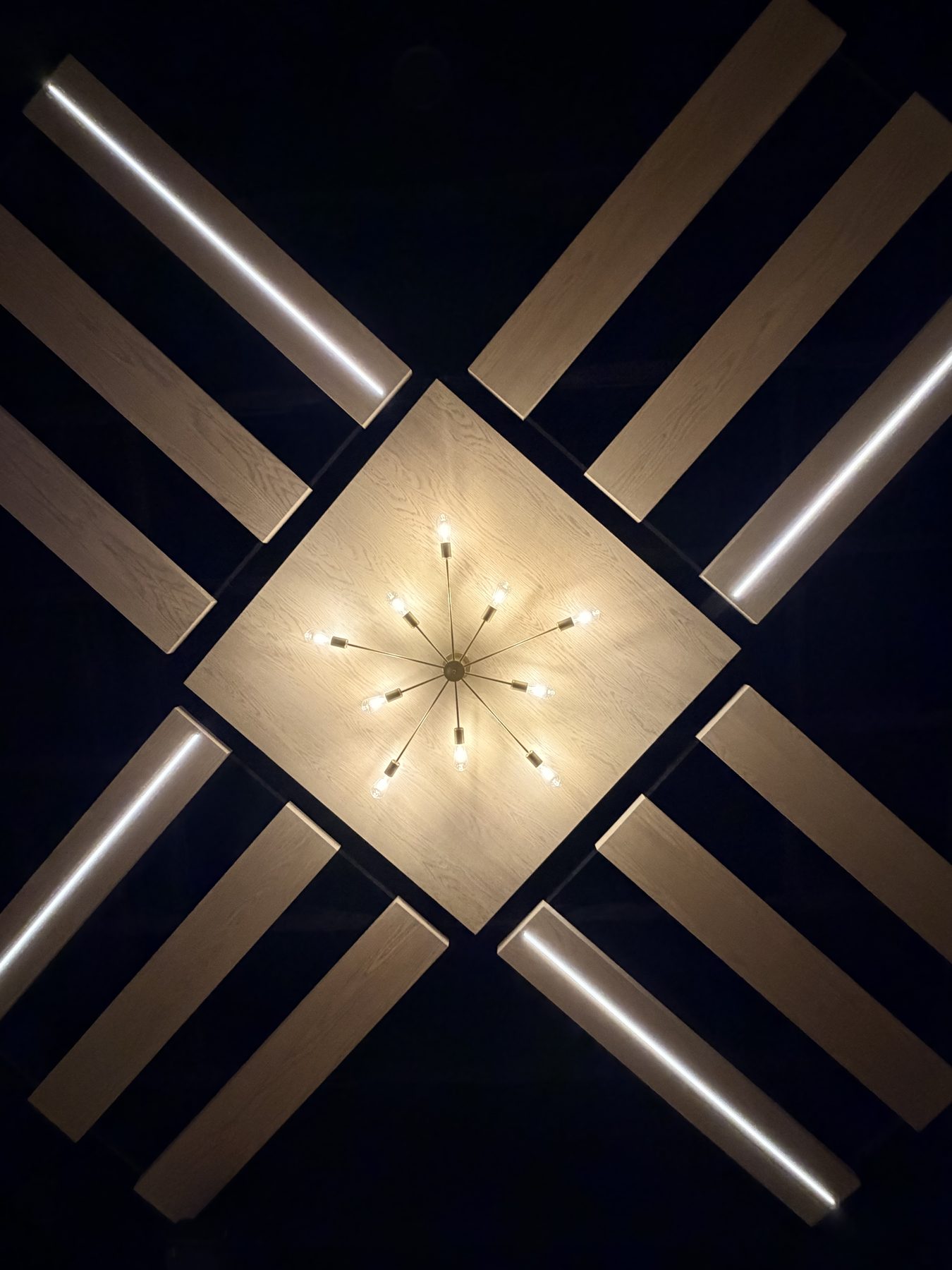 Modern ceiling with wood panels, recessed lighting, and starburst chandelier — The Barron Venue