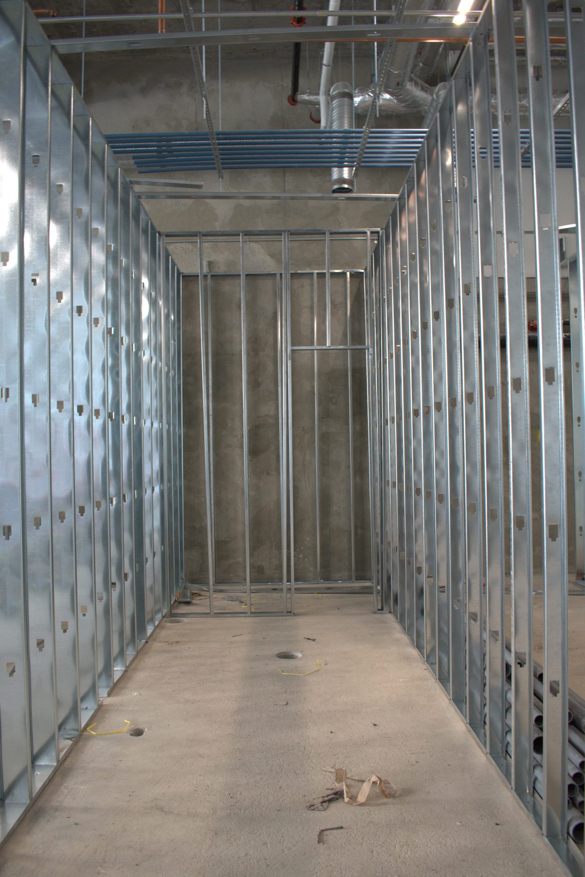 Interior metal stud framing with concrete floor and ceiling infrastructure — Leela Spa (West District)