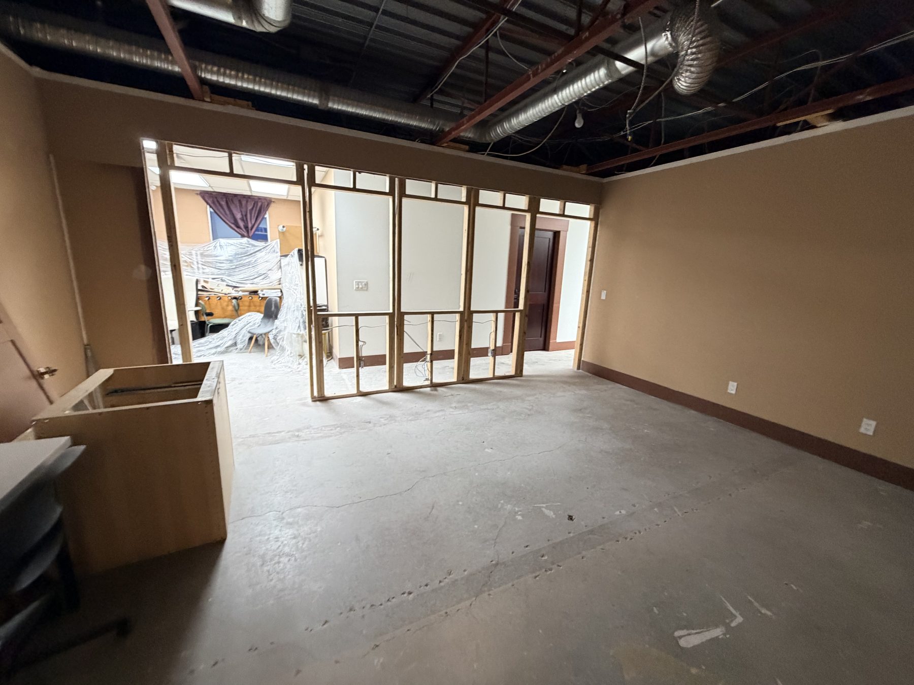 Office space under renovation with exposed ceiling ducts and framing — The Barron Venue