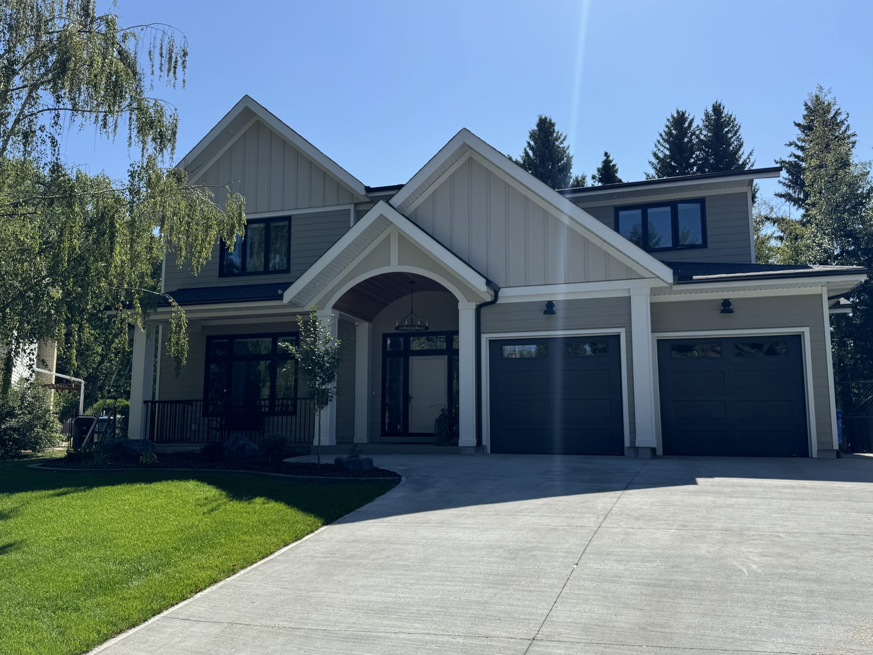 Newly constructed modern house with gray siding and dark garage doors — 18 Varsplain Place Northwest
