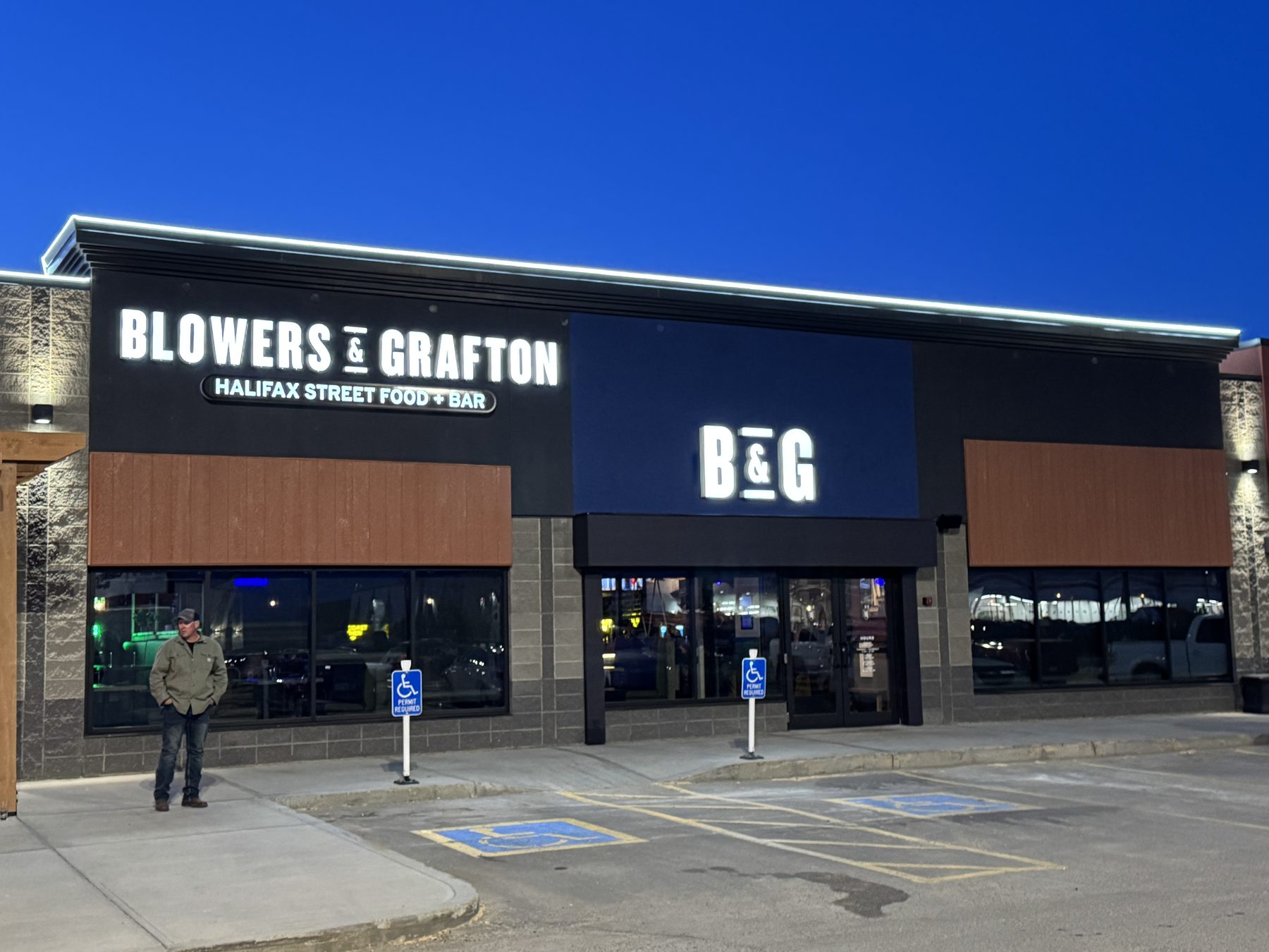 Restaurant exterior with illuminated signage, wood paneling, and signage — Blowers and Grafton (Lloydminster)
