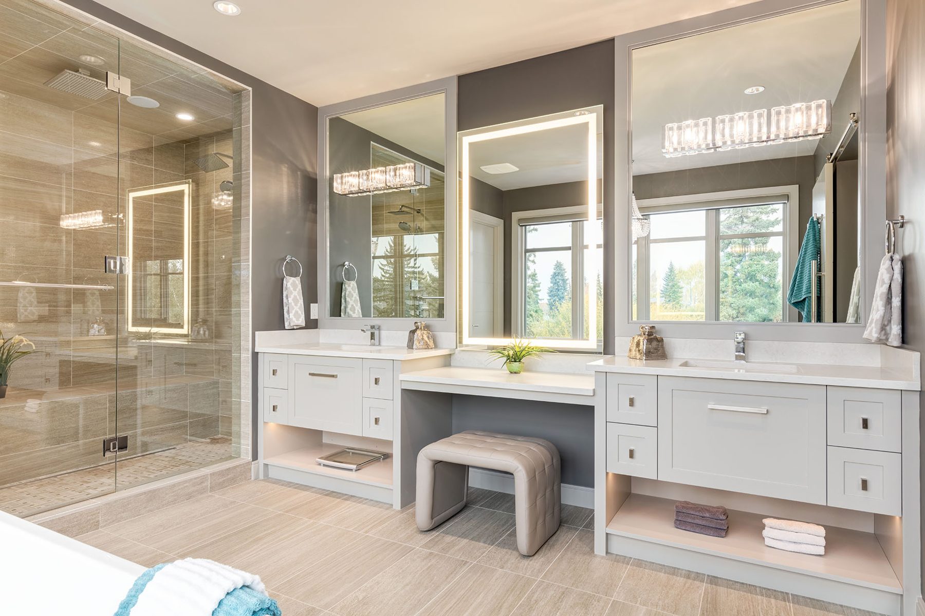 Luxurious bathroom with modern vanity, tiled shower, and large mirrors — The Cellar
