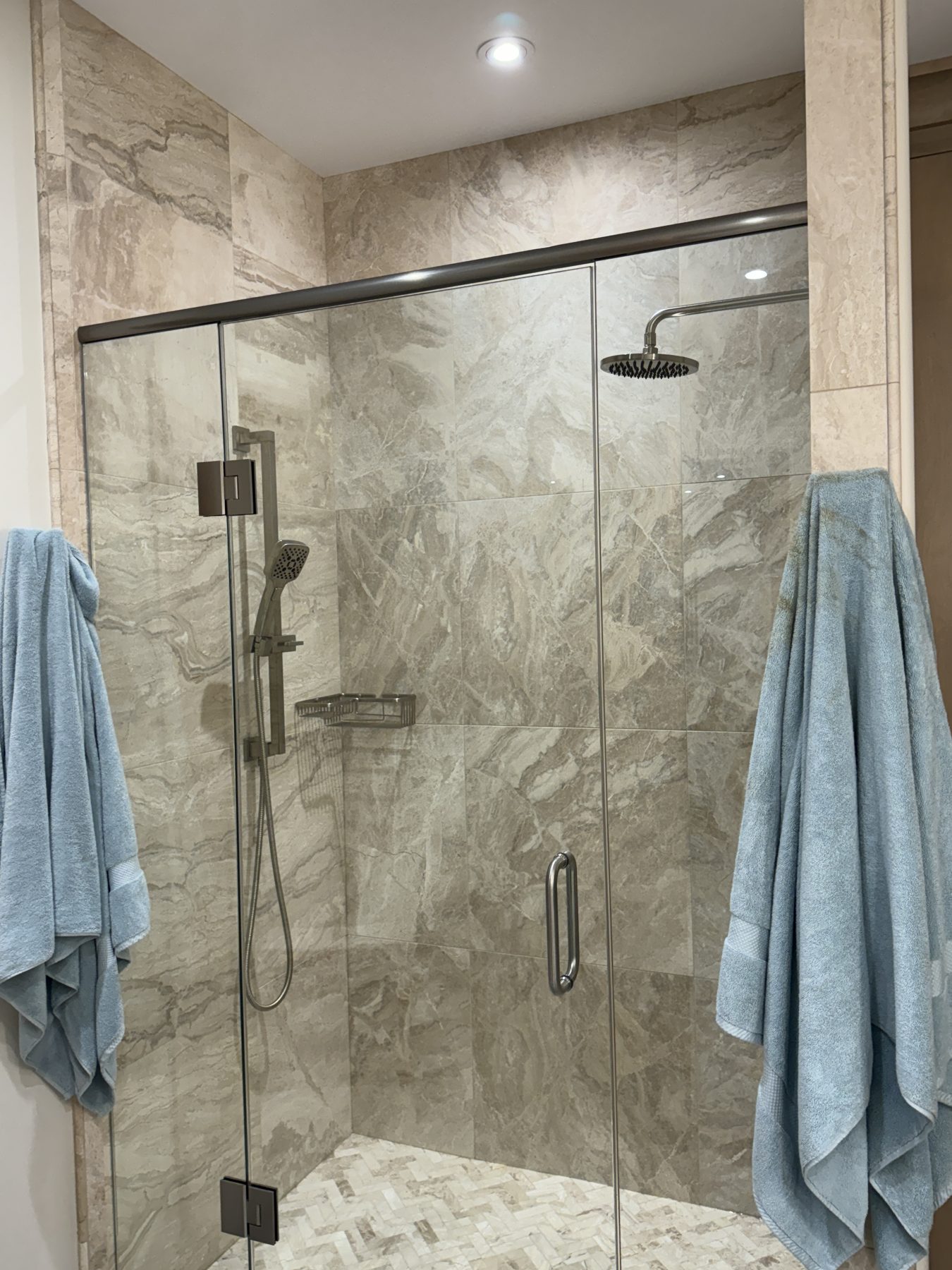 Marble tiled shower stall with glass door, rainfall showerhead, and handheld sprayer — 18 Varsplain Place Northwest