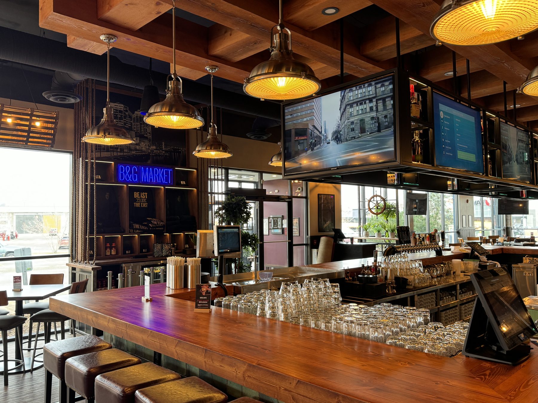 Bar with wooden counter, leather stools, and hanging industrial lights — Blowers and Grafton (Shawnessy)