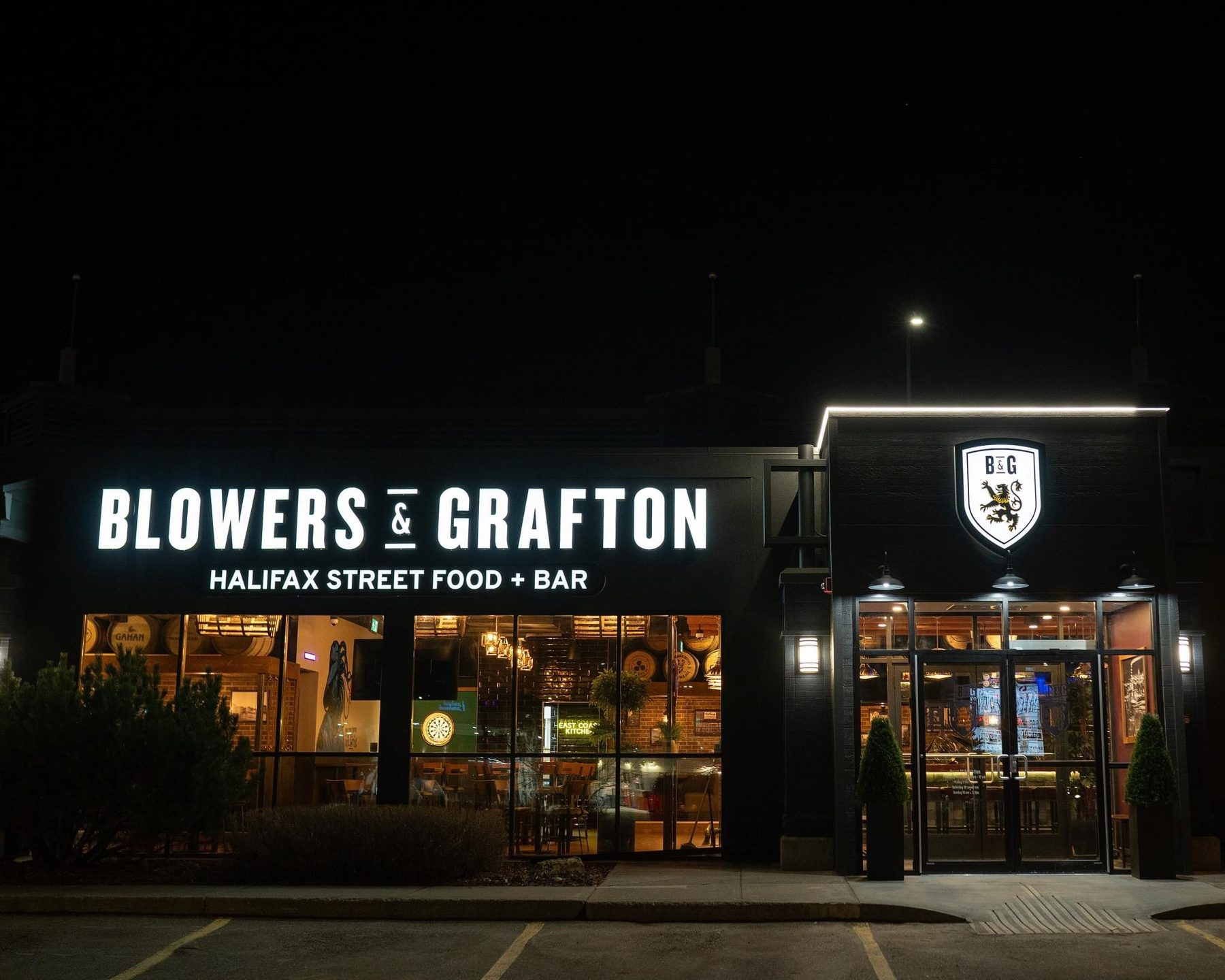 Restaurant exterior at night with illuminated sign and interior visible — Blowers and Grafton (Shawnessy)