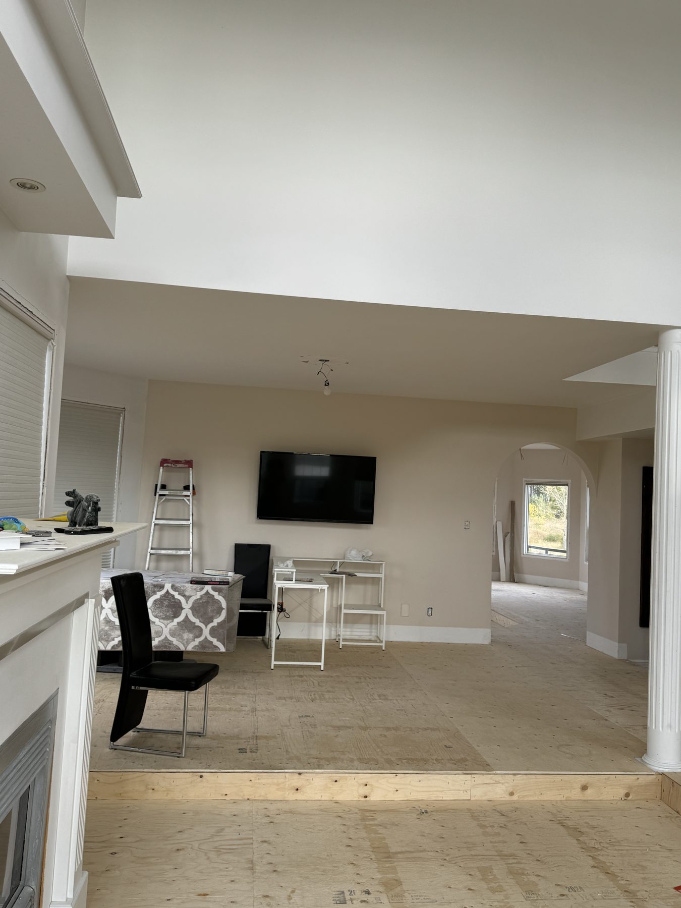 Living room with plywood flooring, television, and step down to another area — 14 Lochend Drive, Cochrane