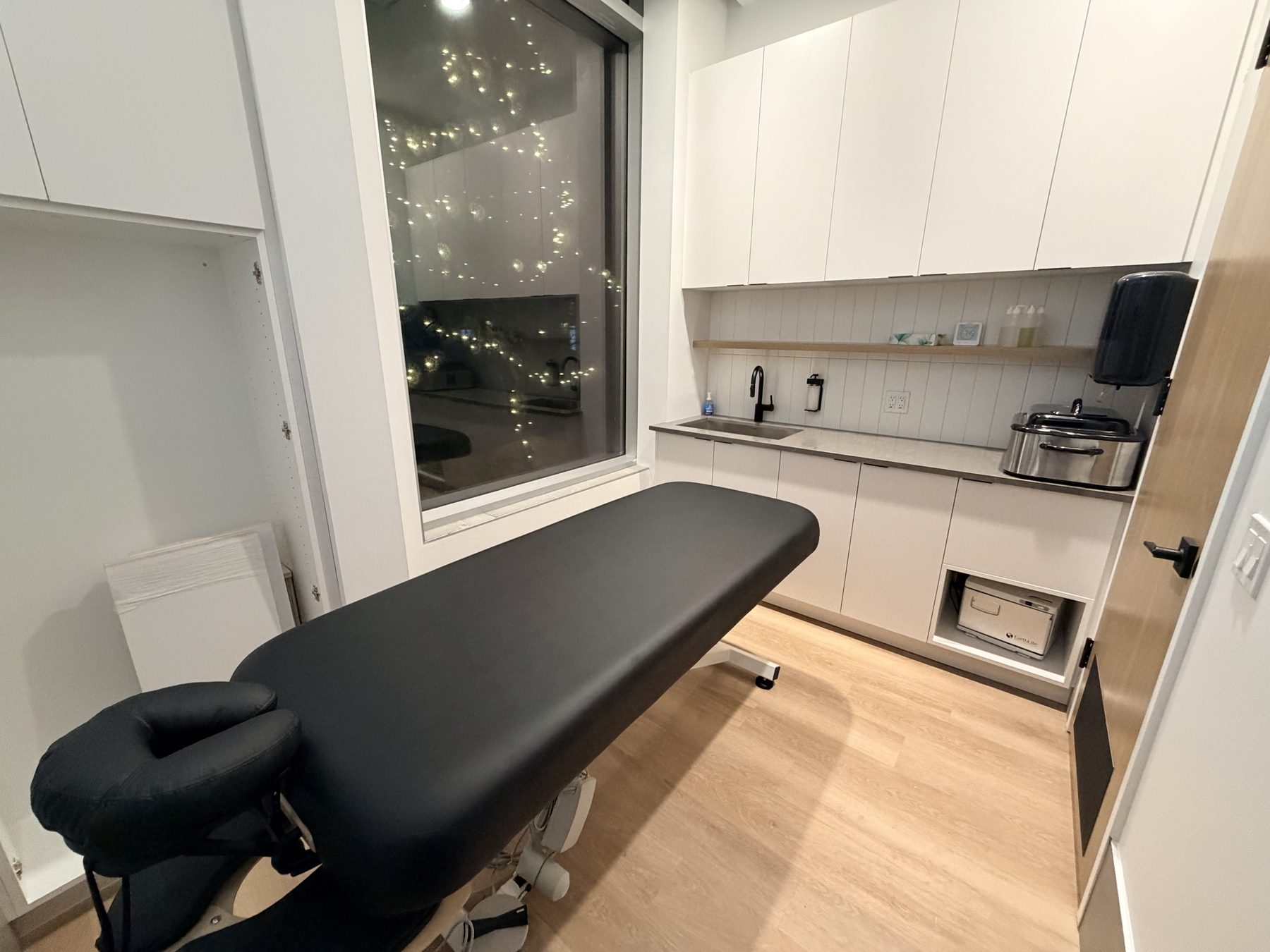 Modern clinic room with massage table and white cabinetry — Cedar Steam and Spa (Trinity Hills)