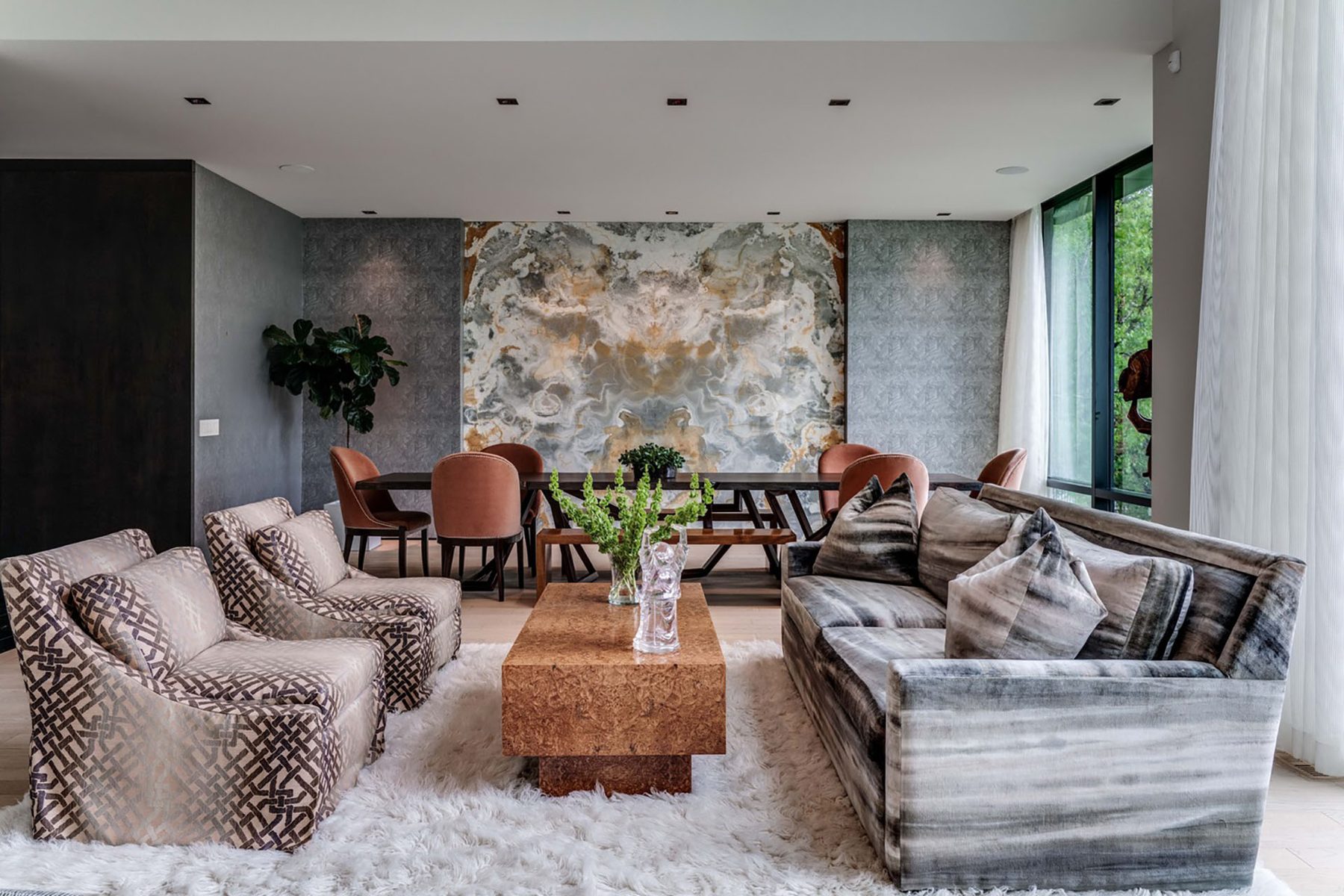 Modern living and dining room with patterned upholstery and marble wall — Modern Family