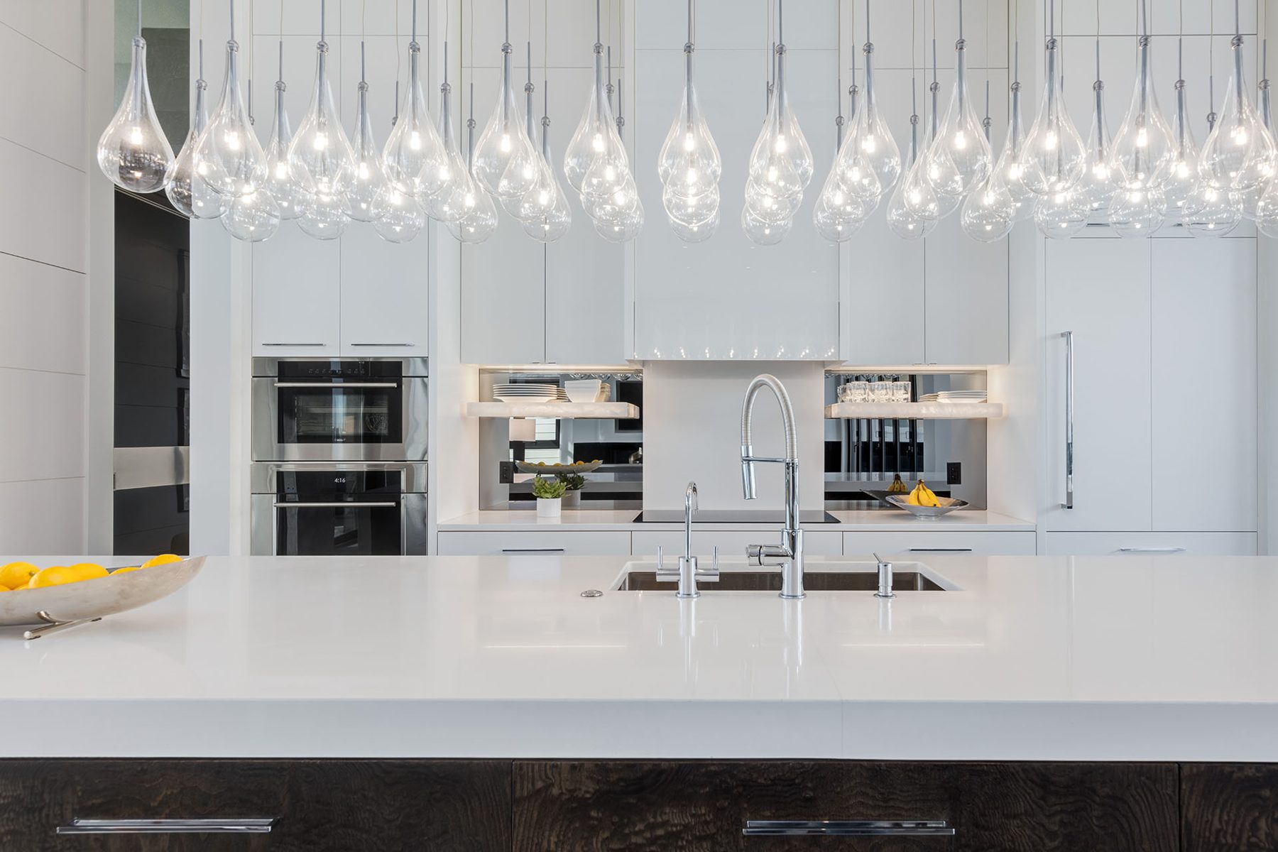 Modern kitchen island with waterfall countertop and stainless steel appliances — Infinity
