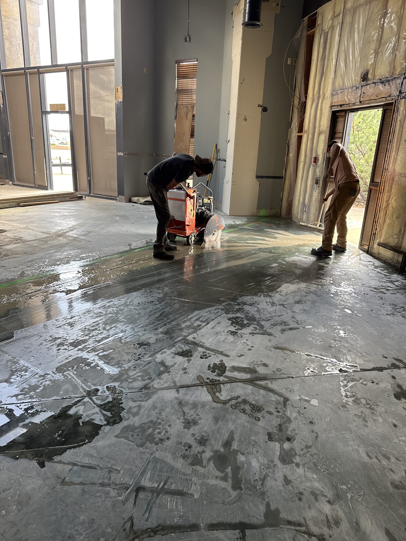 Workers wet-cut concrete floor during renovation project — Blowers and Grafton (Red Deer)
