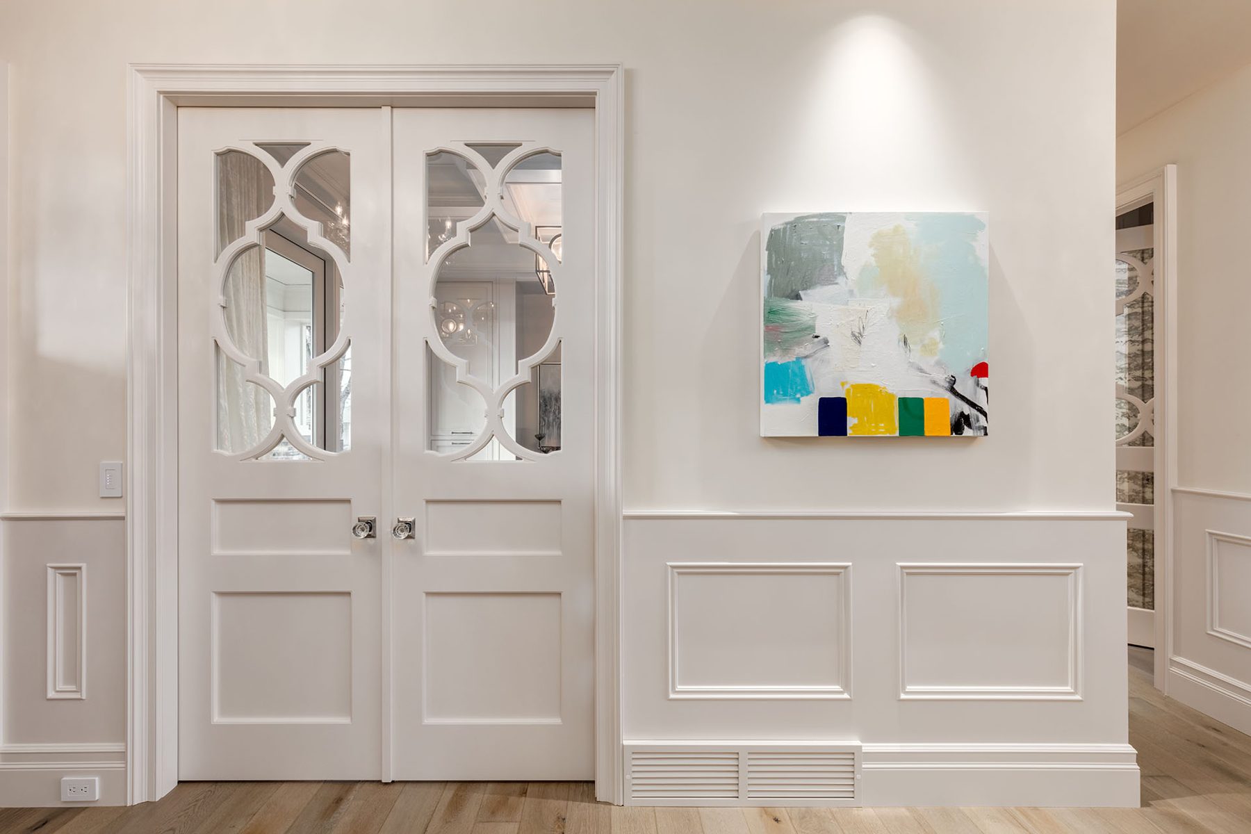 White French doors with decorative glass, modern art, and wainscoting — White House