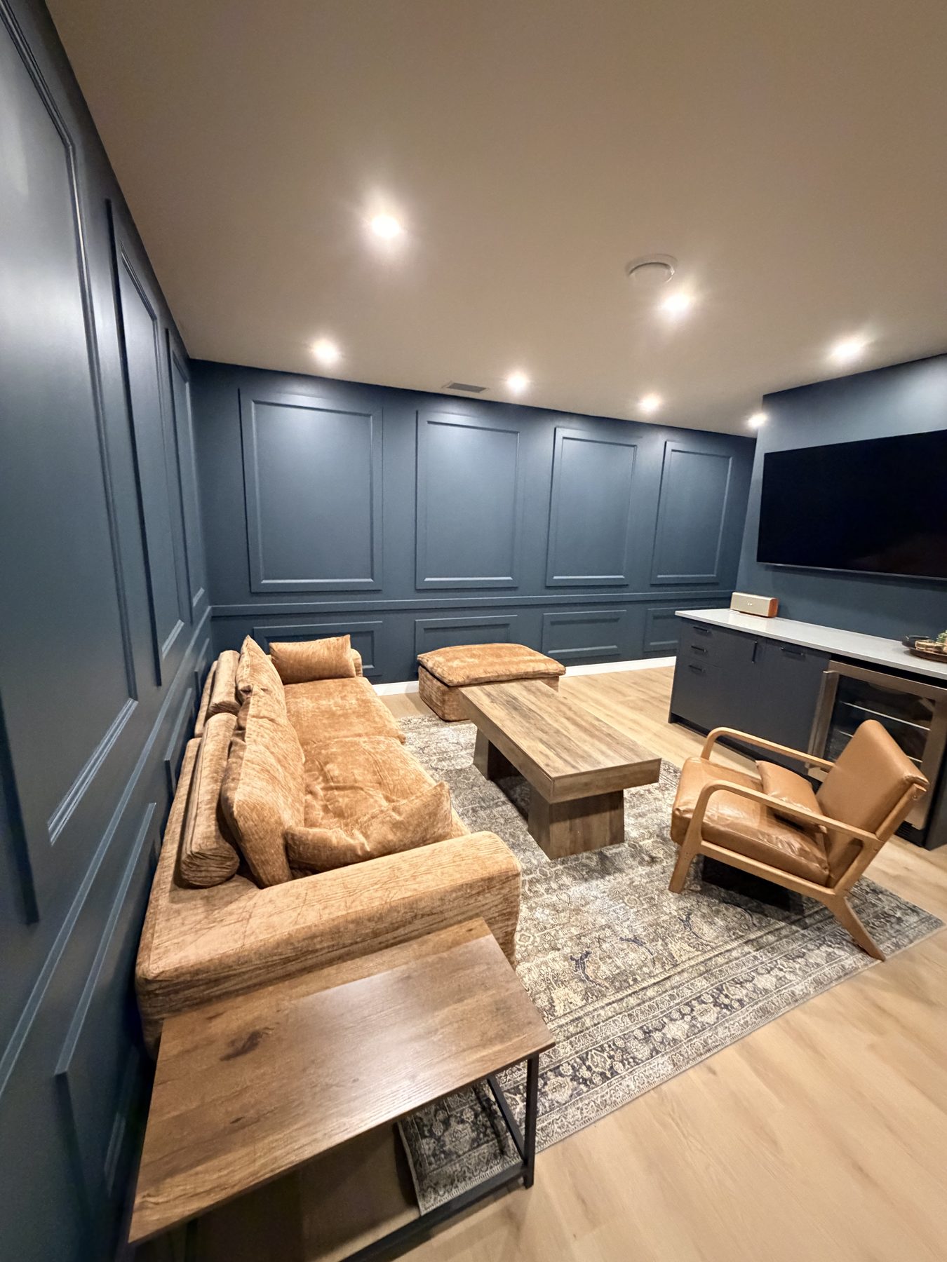 Living room with dark blue paneled walls and new furniture — The Barron Venue