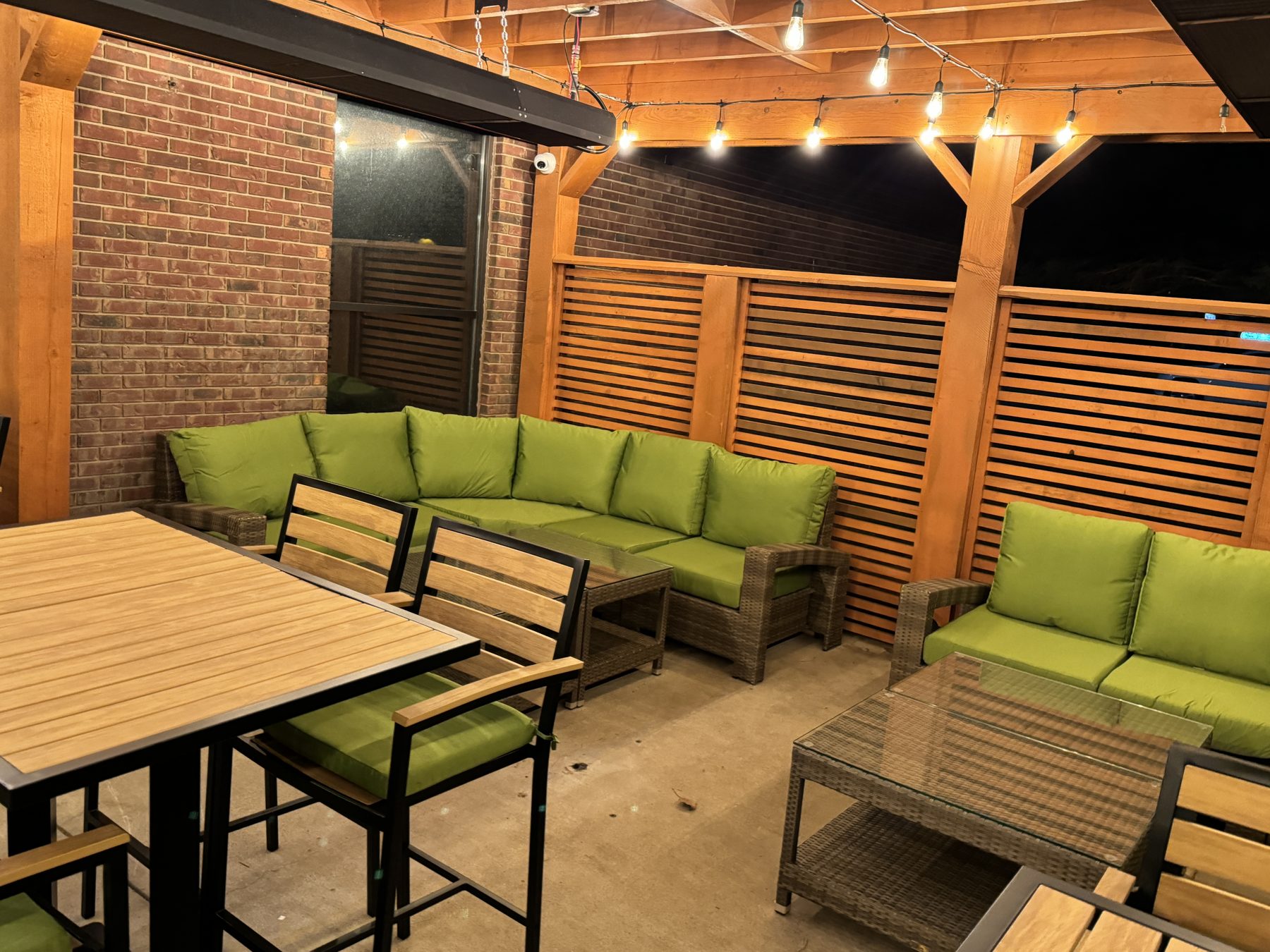 Outdoor patio with furniture, brick wall, wooden slatted walls and string lights — Blowers and Grafton (Medicine Hat)