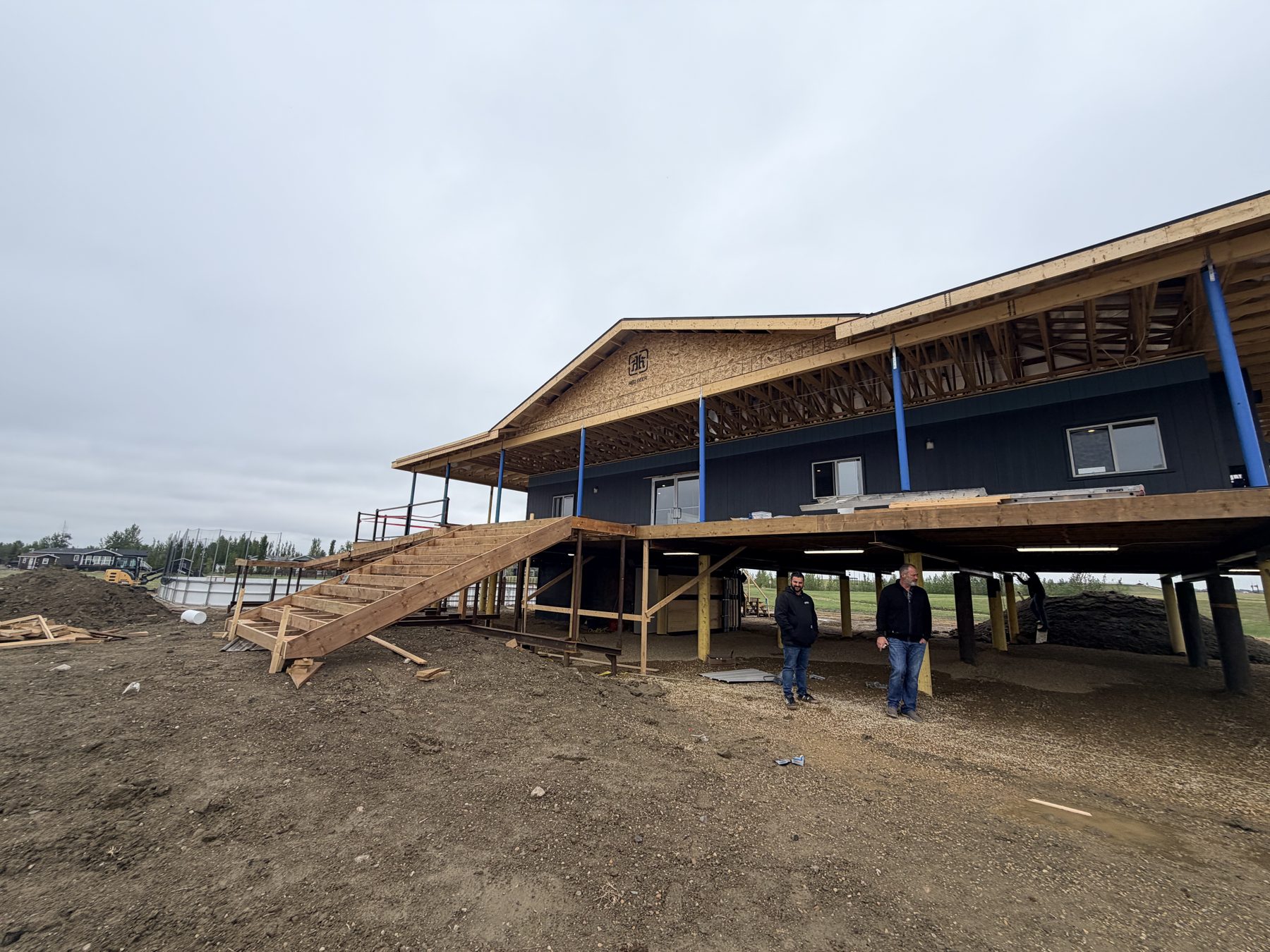 Elevated house construction with wooden stairs and dark siding — Sandy Point (Club House)