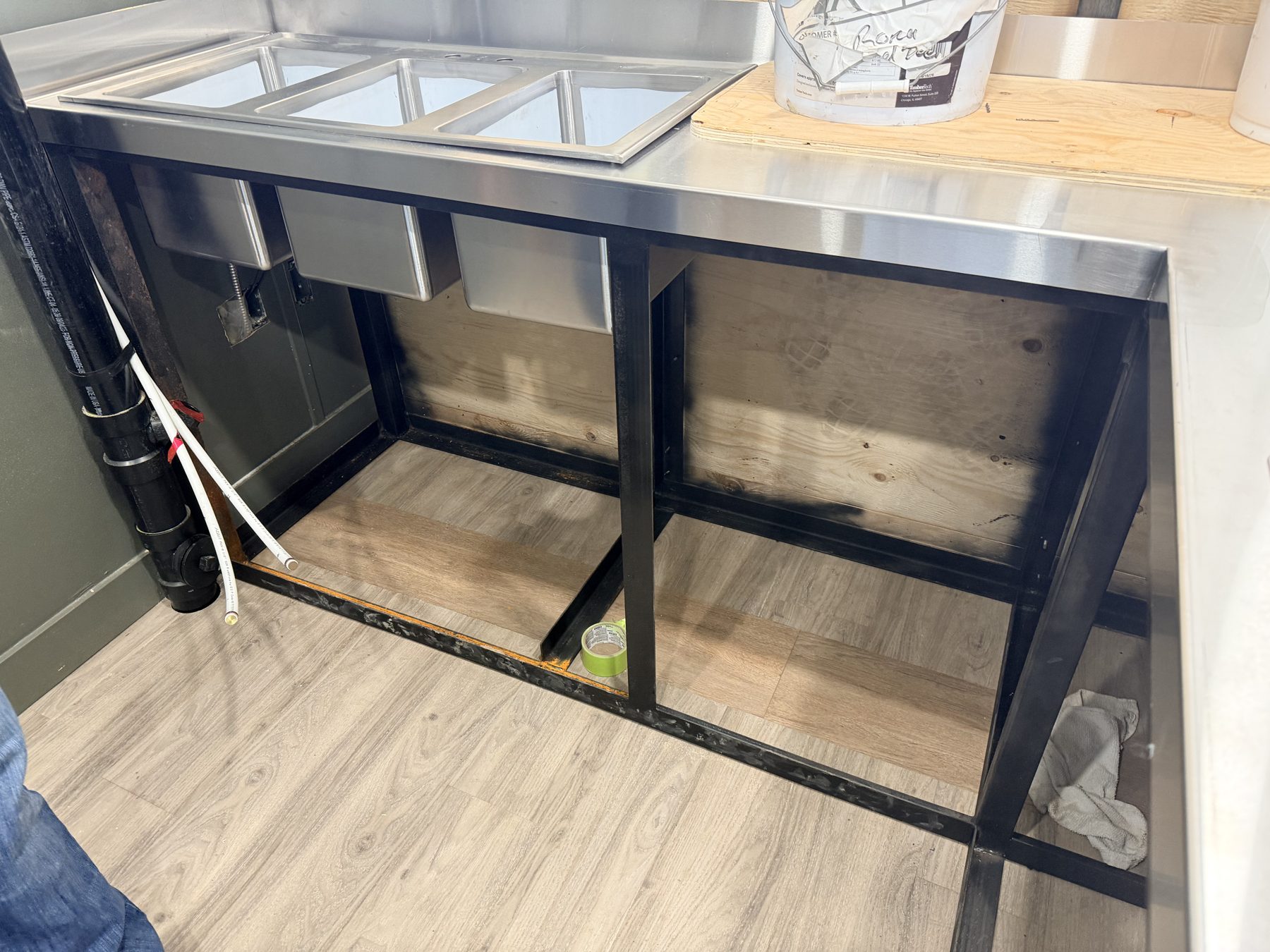 Stainless steel sink installed on metal frame, awaiting cabinetry completion — Sandy Point (Club House)