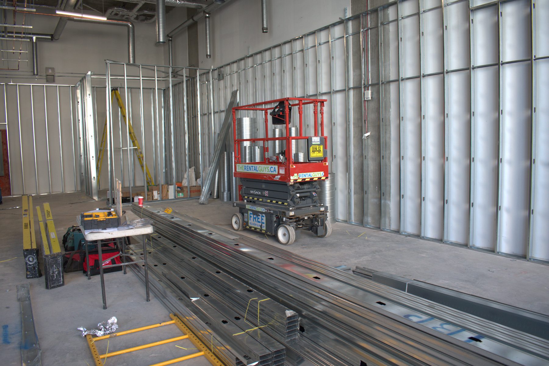 Scissor lift and metal studs in unfinished room during construction — Leela Spa (West District) by Onsite Contracting Services