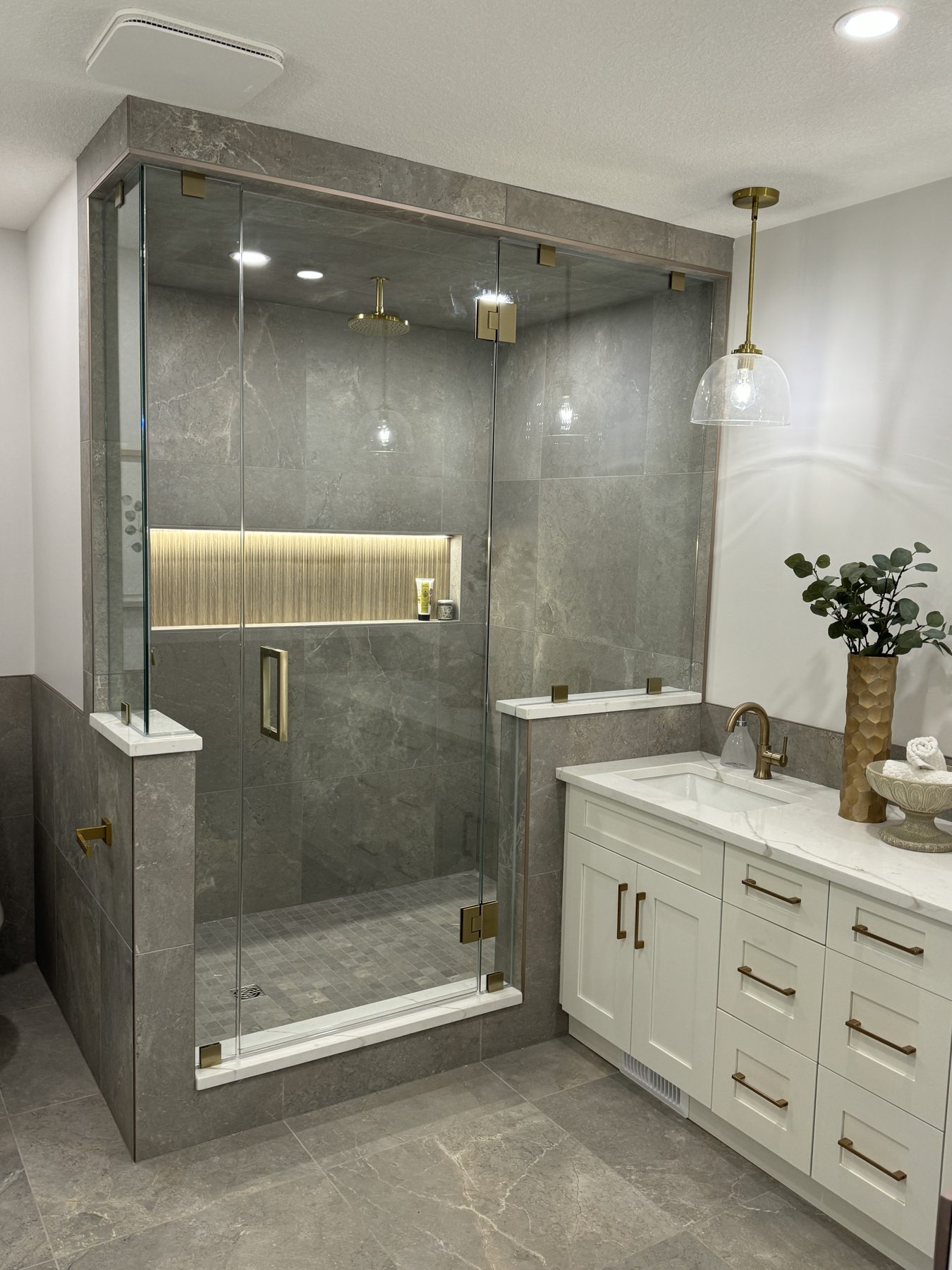 Modern bathroom renovation with marble-look tile, glass shower, and vanity — Lake Bonavista