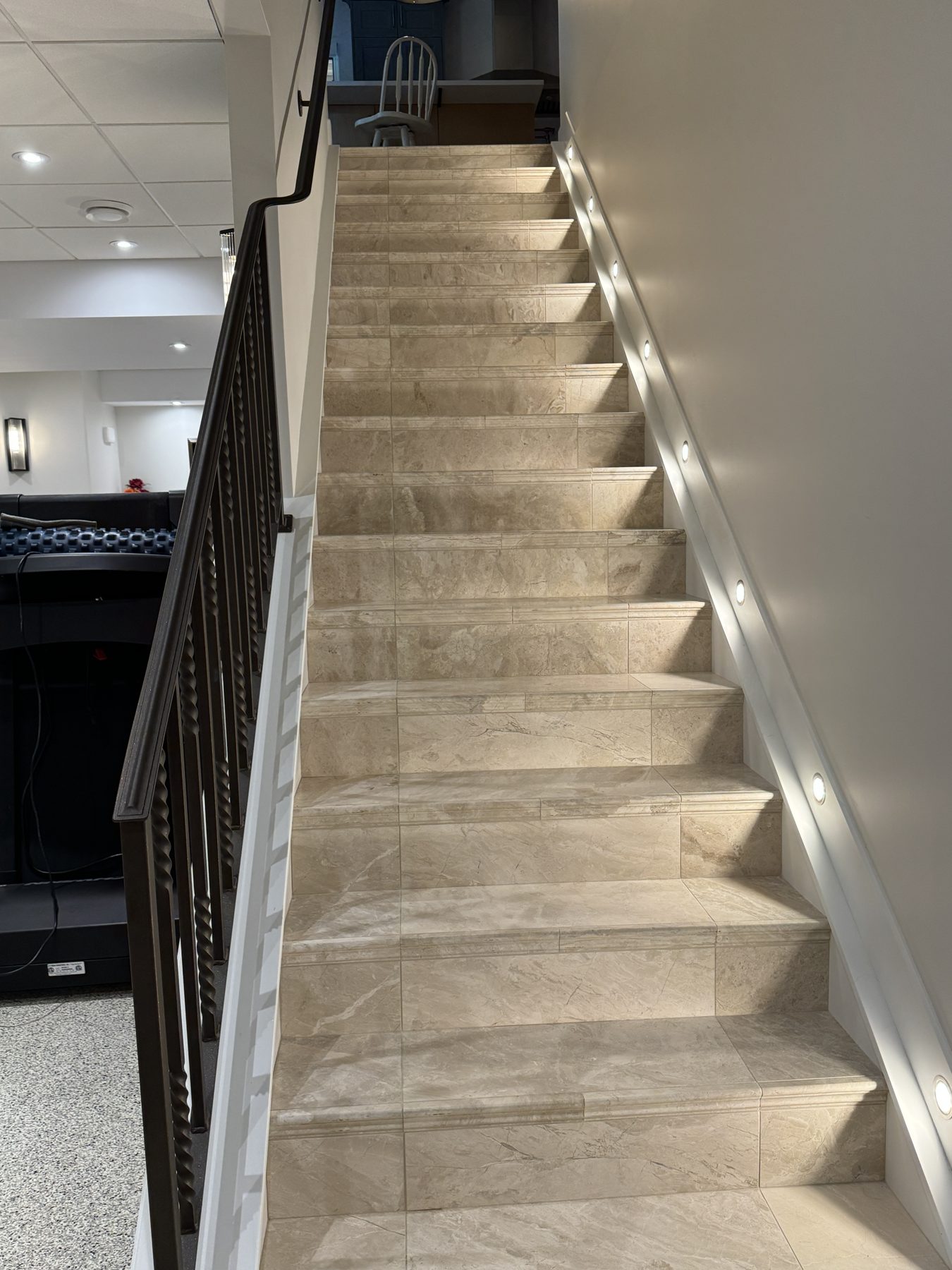 Tiled basement stairs with dark railing and recessed lighting — 18 Varsplain Place Northwest