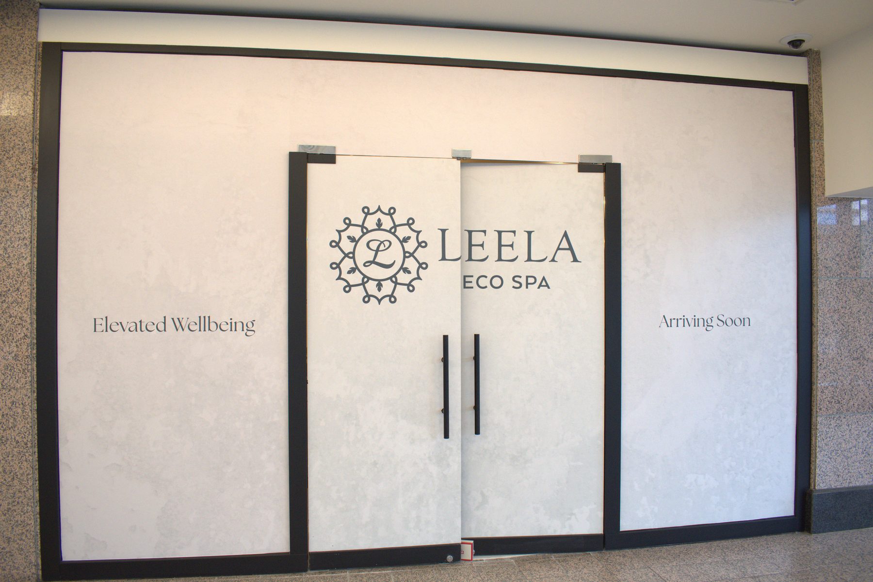 Spa entrance with frosted glass doors, black frames, and temporary signage — Leela Spa (Bankers Hall) by Onsite Contracting Services