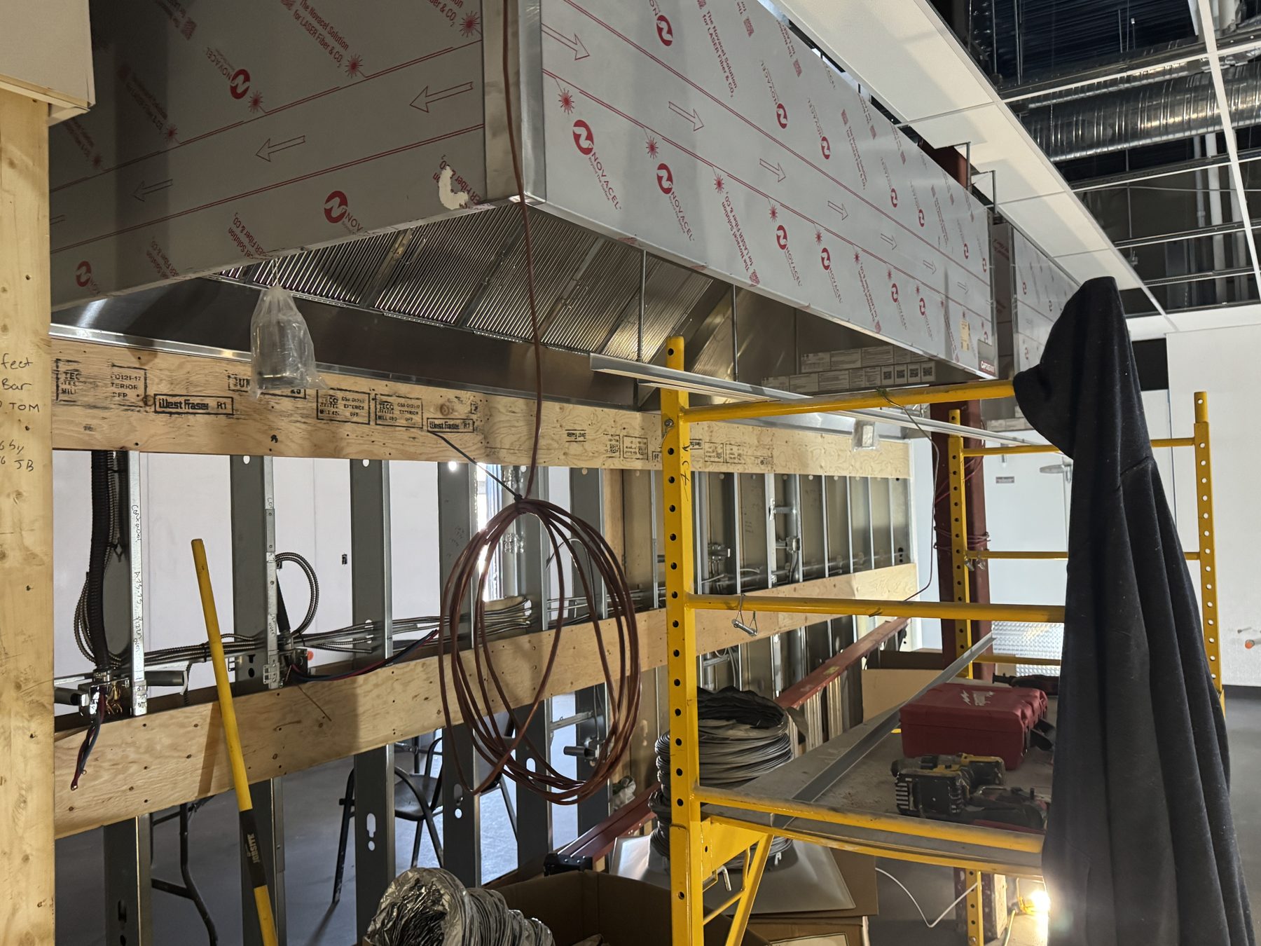 Commercial kitchen renovation with large stainless steel vent hood and scaffolding — Blowers and Grafton (Red Deer)