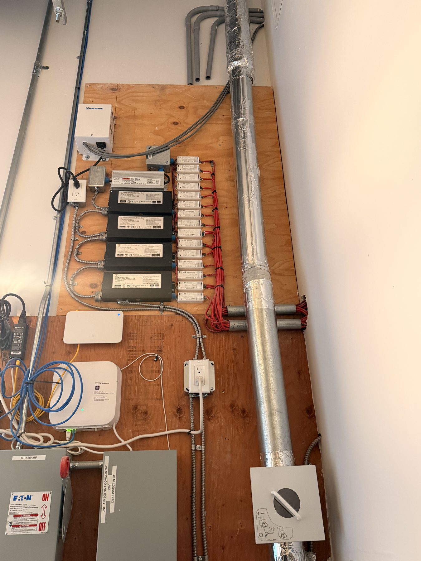 Electrical panel, power supplies, and HVAC components mounted on plywood wall — Cedar Steam and Spa (Trinity Hills)