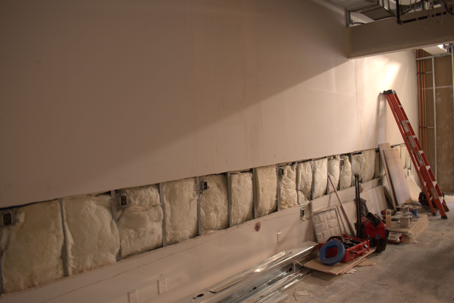Interior wall insulation installation with tools and ladder present — Big Buns (Bowness)