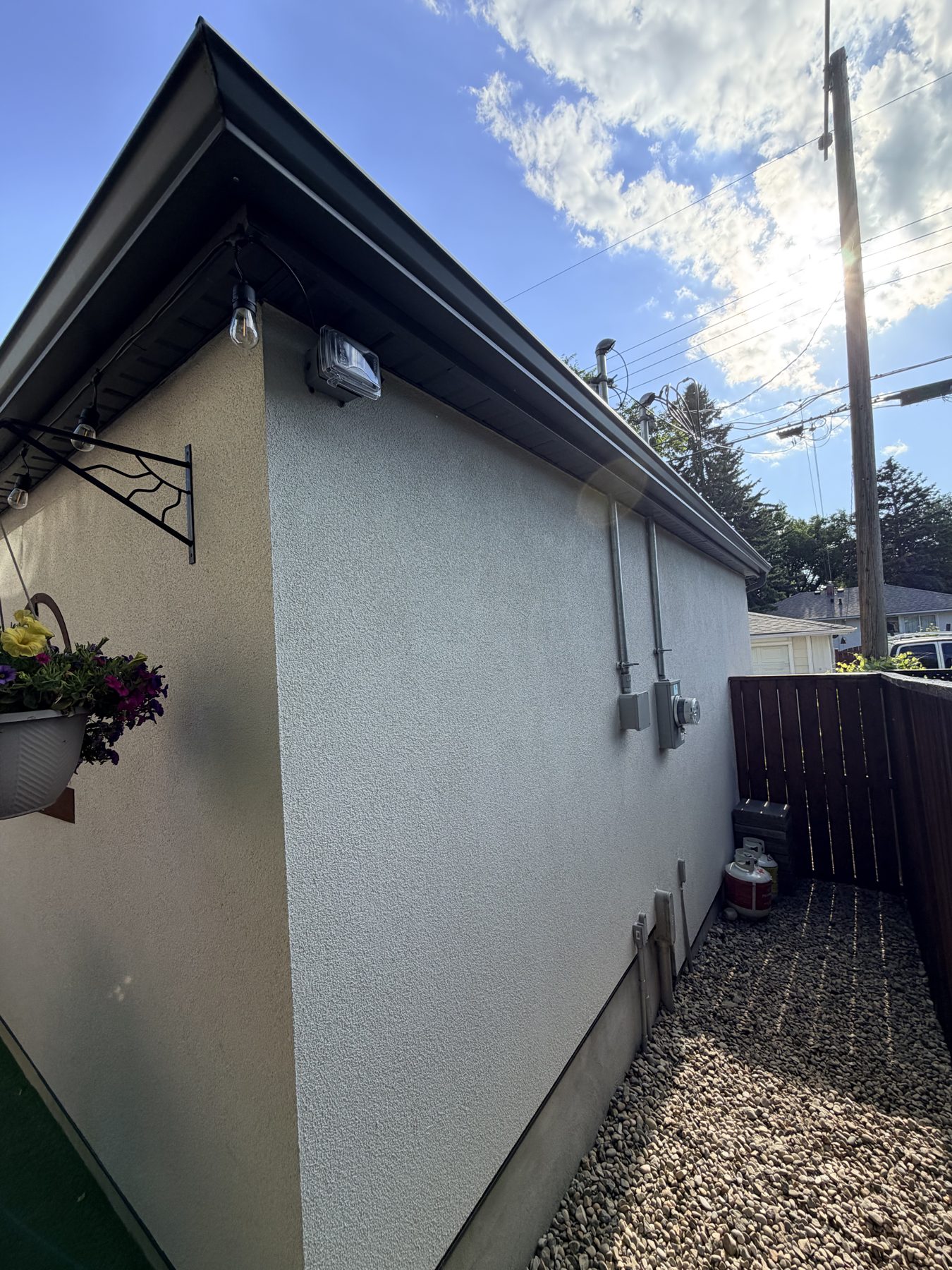 Exterior wall with stucco, new gutters, lights, and electrical meter — 3505 41 Street SW, Calgary