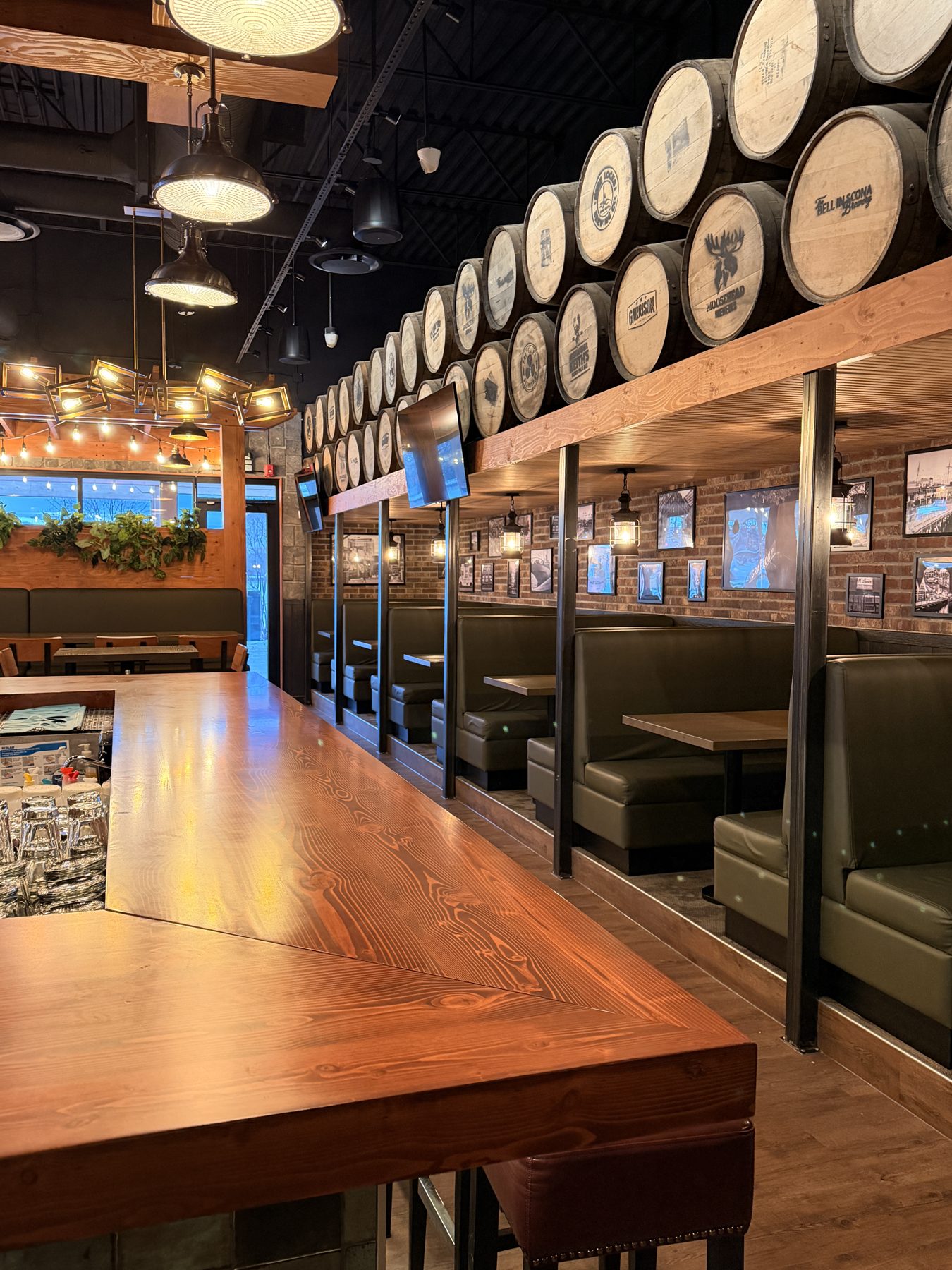 Restaurant dining area with wood bar, booths, and barrels — Blowers and Grafton (Red Deer)