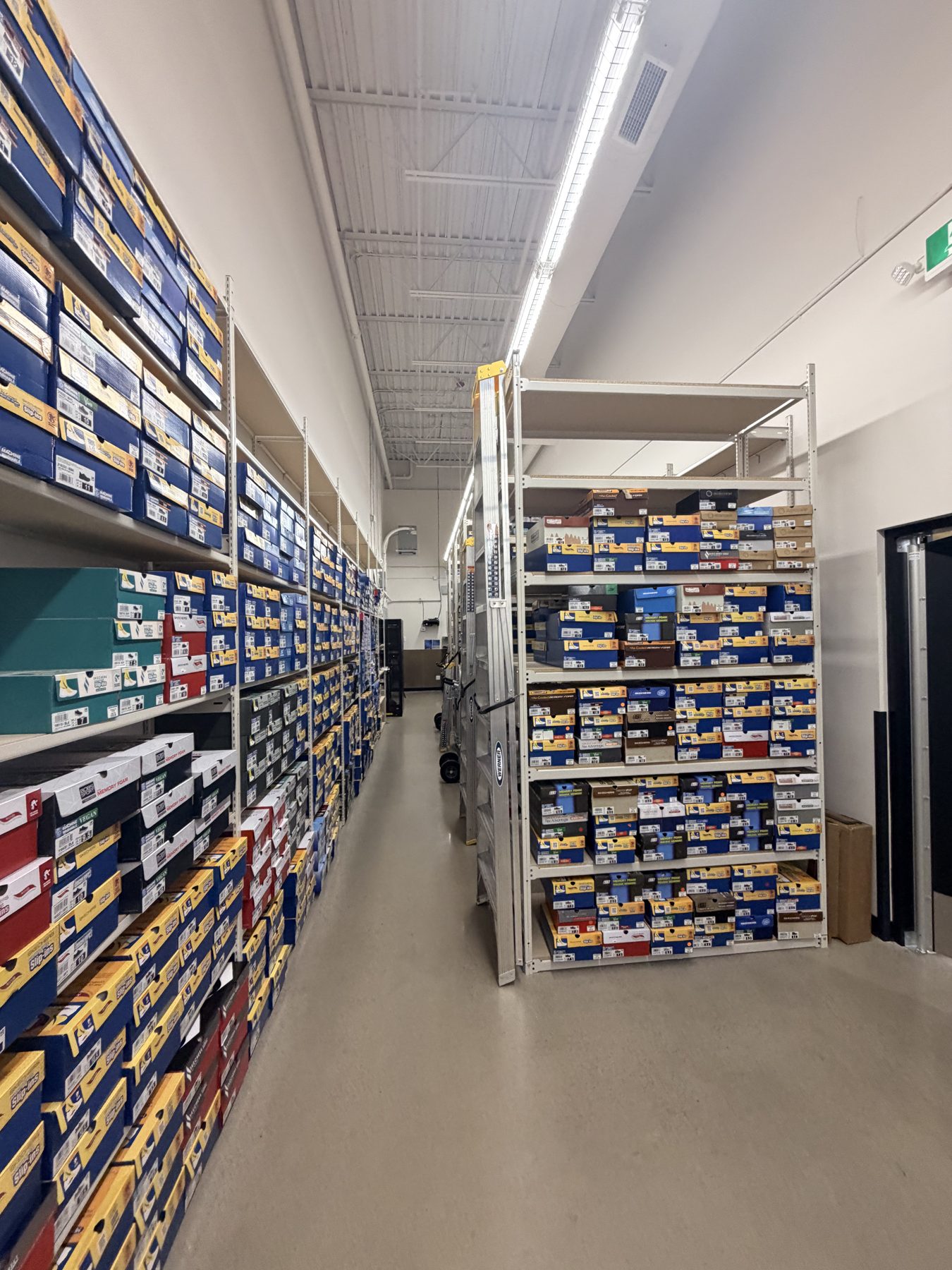 Shoe boxes stacked high on shelving units in a warehouse — Skechers (Signal Hill)