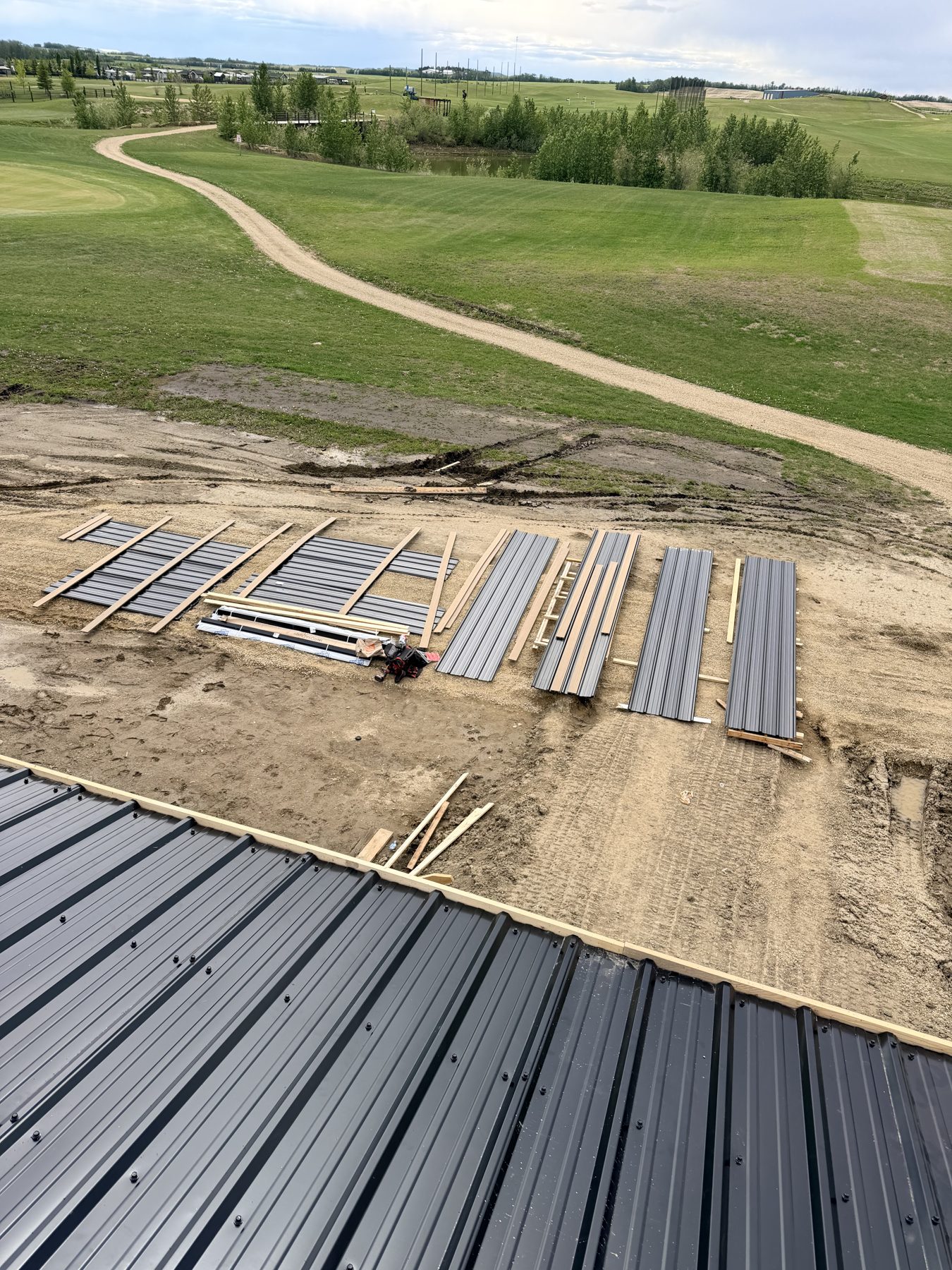 Dark gray metal roofing panels laid out on construction site — Sandy Point (Club House)