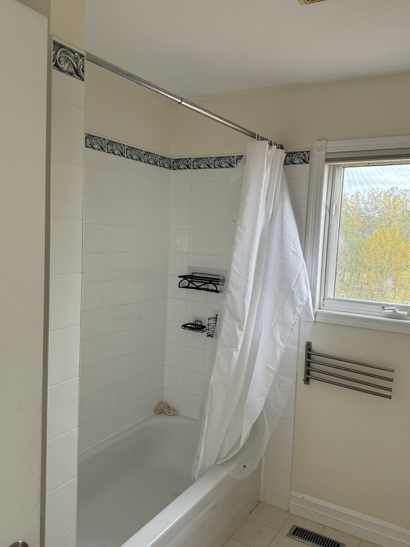 Tiled shower stall with white curtain, bathtub, and window view — 14 Lochend Drive, Cochrane