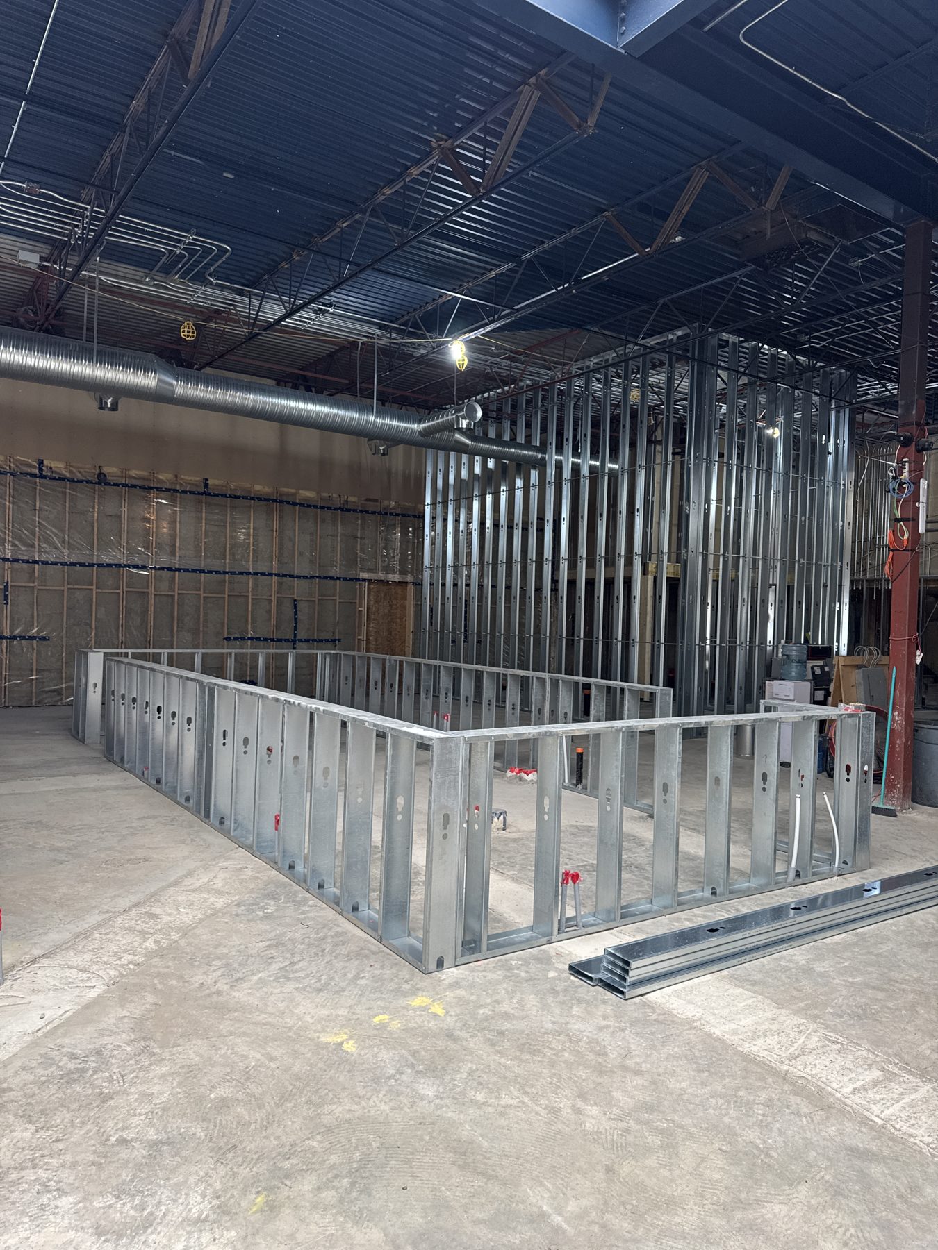Metal stud framing and HVAC ductwork in unfinished commercial space — Blowers and Grafton (Red Deer)