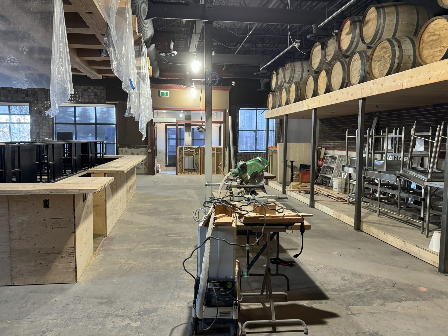 Construction underway with unfinished bar, barrels, and chop saw — Blowers and Grafton (Medicine Hat)