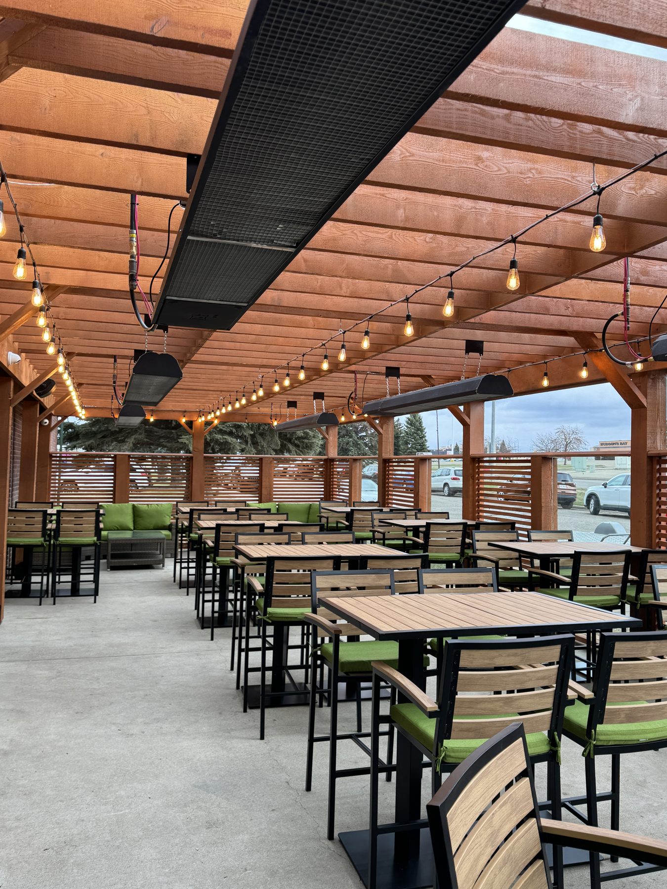 Outdoor patio with tables, chairs, heaters, and string lights — Blowers and Grafton (Medicine Hat)