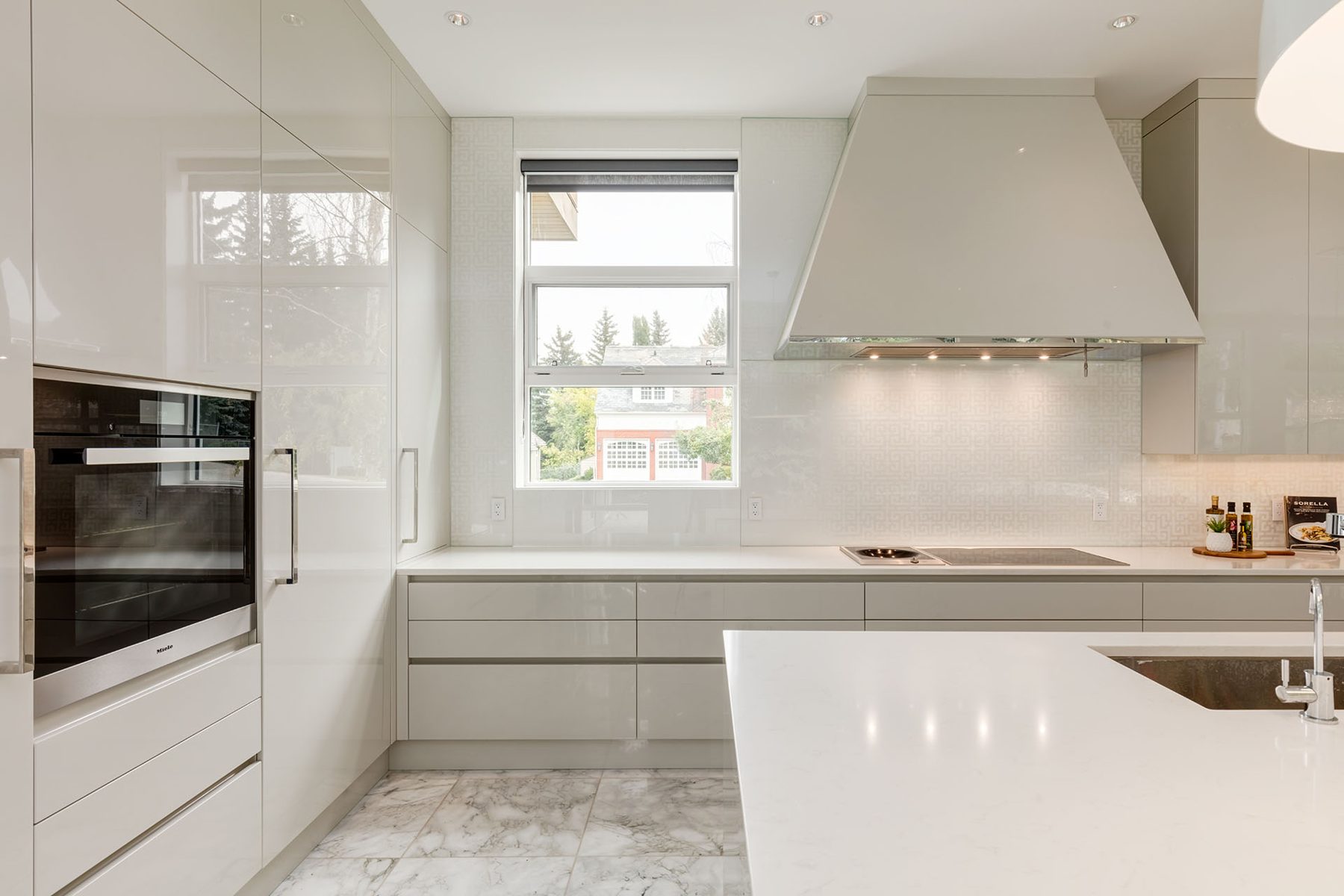 Modern white kitchen with stainless steel appliances and marble floors — Germania