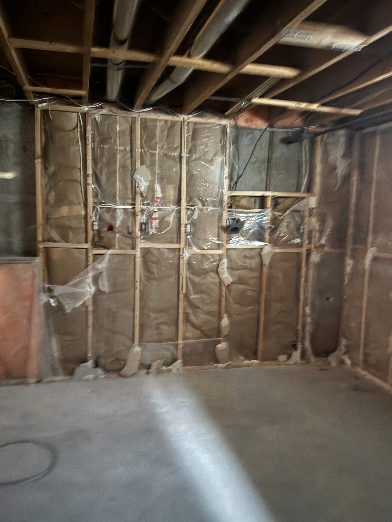 Unfinished basement framing with insulation and exposed ceiling pipes — 188 Lake Adams Crescent SE, Calgary