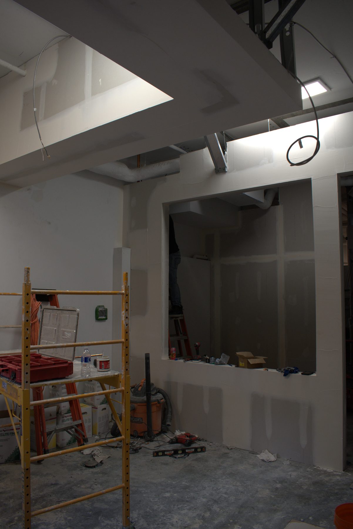 Interior construction with drywall, scaffolding, and power tools on floor — Big Buns (Bowness)