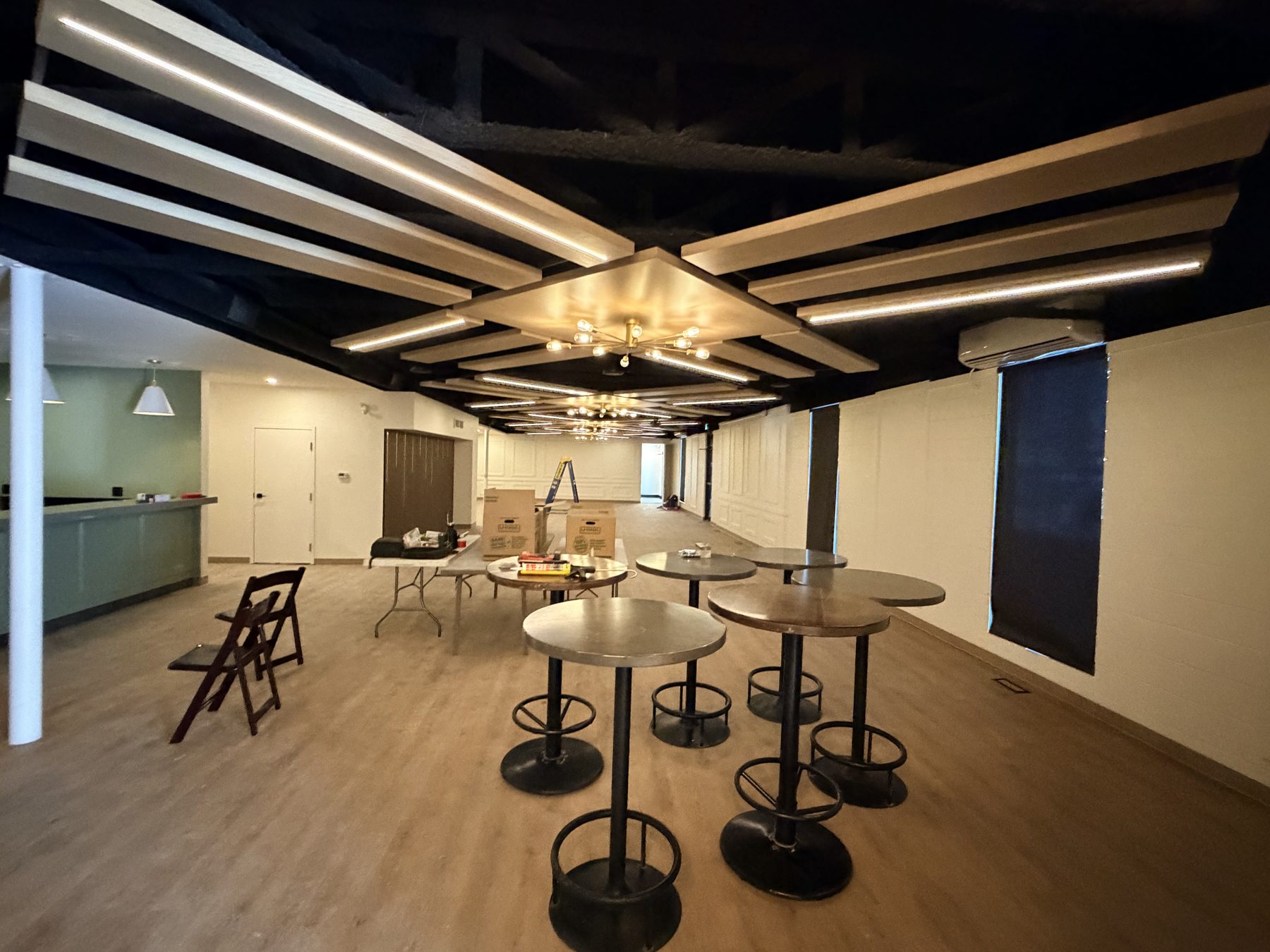 Bar area, modern ceiling with lighting, high-top tables, and bar stools — The Barron Venue
