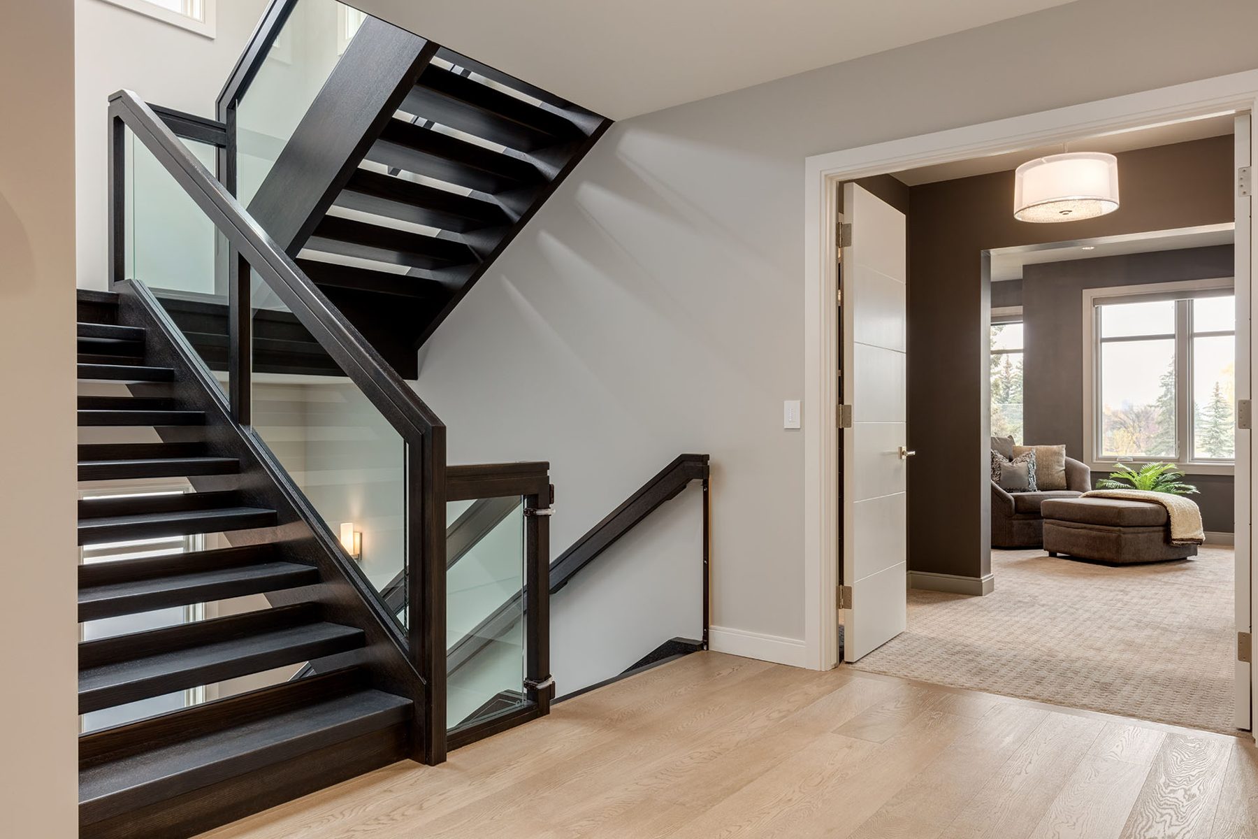 Modern staircase with dark wood treads and glass railings — The Cellar