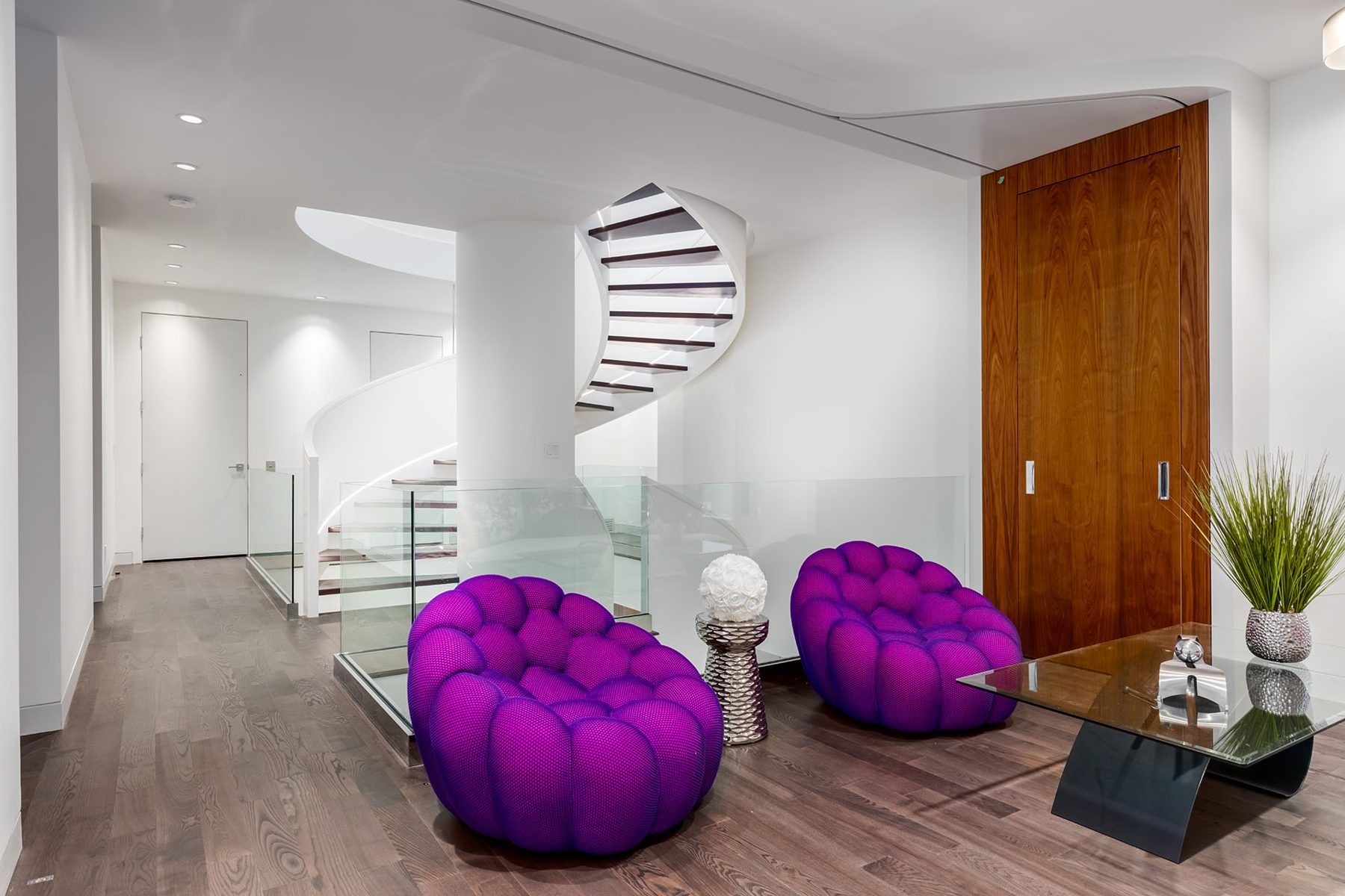 Modern hall with spiral staircase, purple chairs, and glass railings — Timeless Form