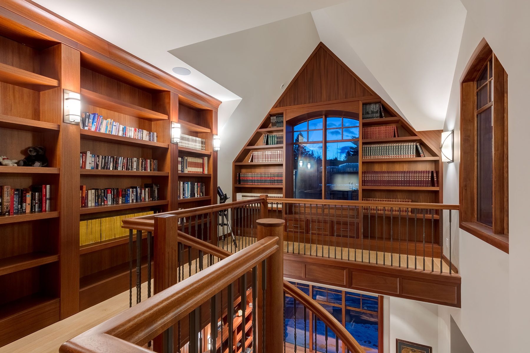 Wood-paneled library with built-in bookshelves and grand staircase — Oxford