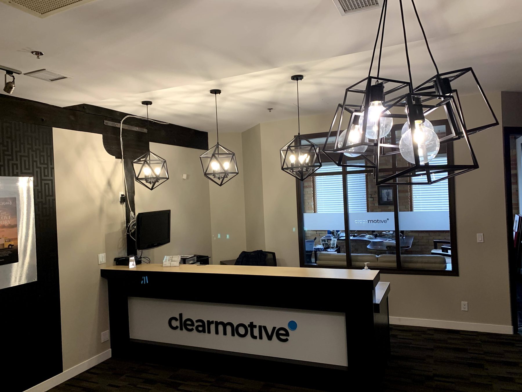 Reception desk and geometric pendant lights in an office — Clearmotive (Victoria Park)