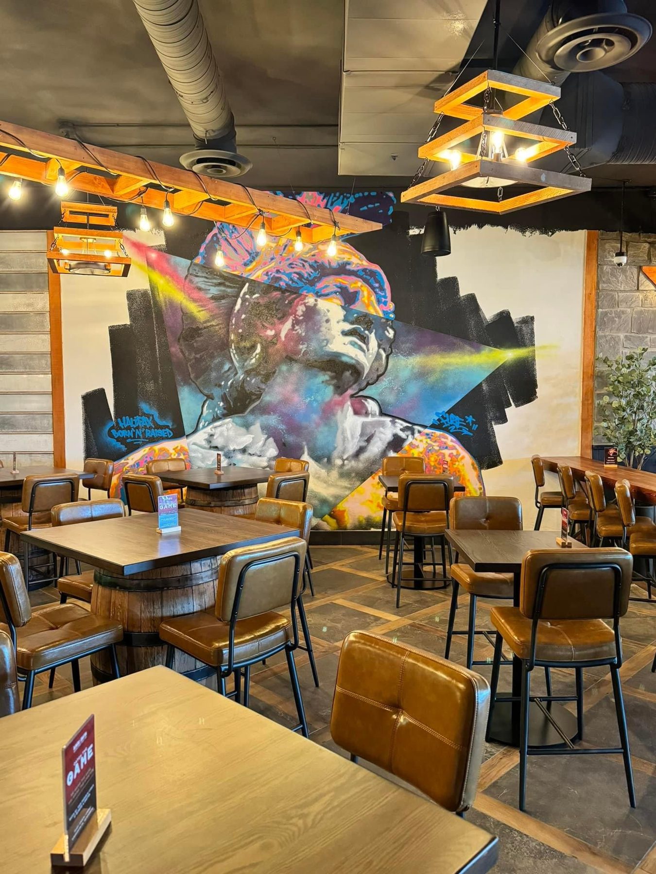 Restaurant dining area with barrel tables, brown leather seating, and mural — Blowers and Grafton (Shawnessy)