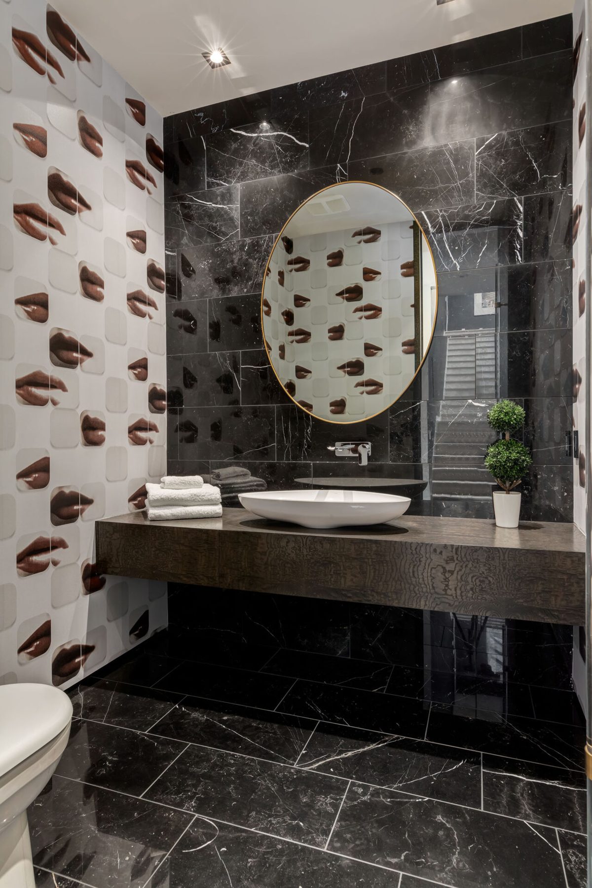 Modern bathroom with marble tiles, floating vanity, and lip-patterned wallpaper — Modern Family