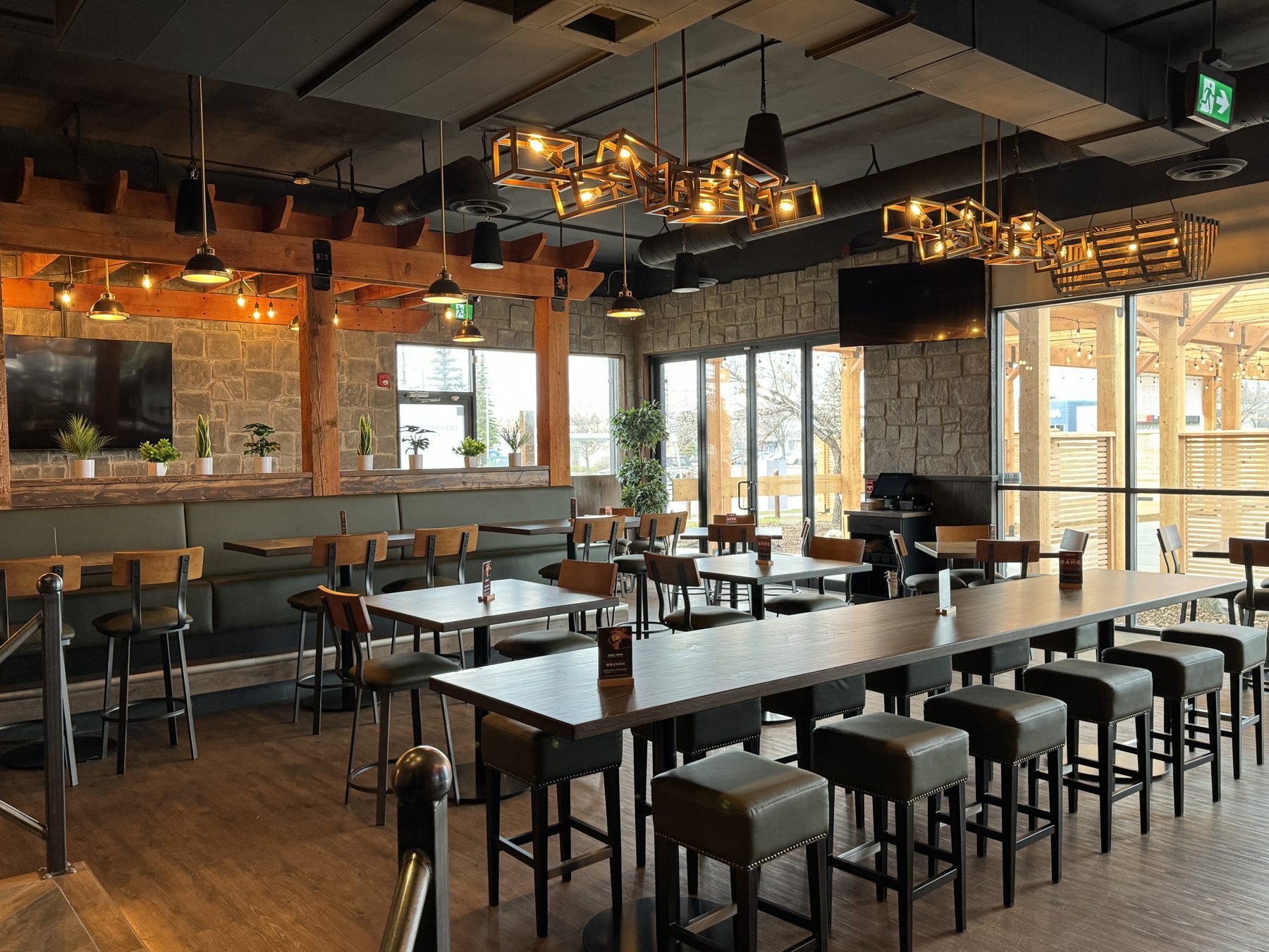 Dining room with stone walls, wooden beams, and modern pendant lights — Blowers and Grafton (Shawnessy)